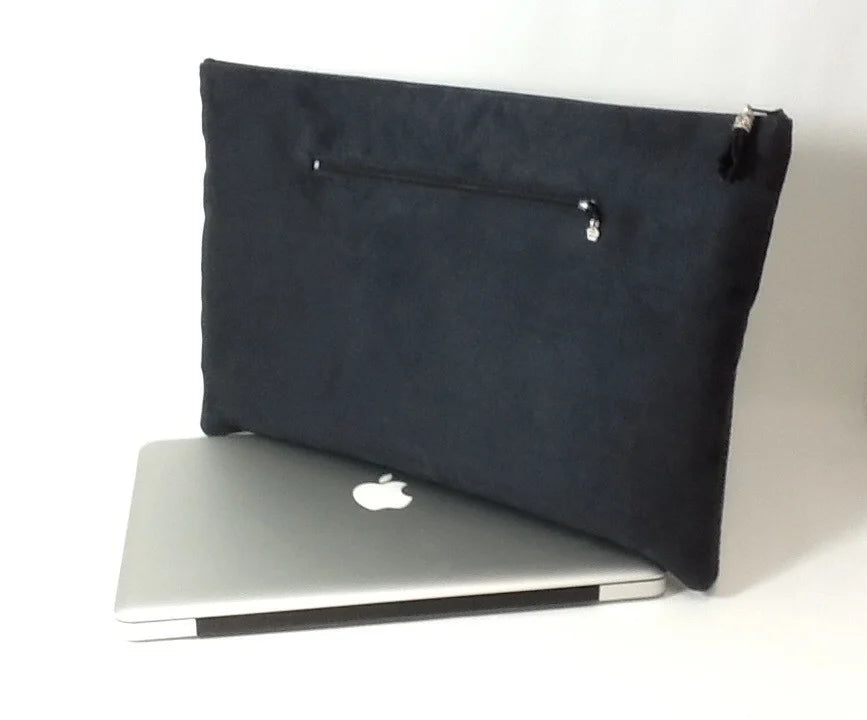 La pochette ordinateur noir et argenté aspect reptile, avec poche chargeur à l'arrière.