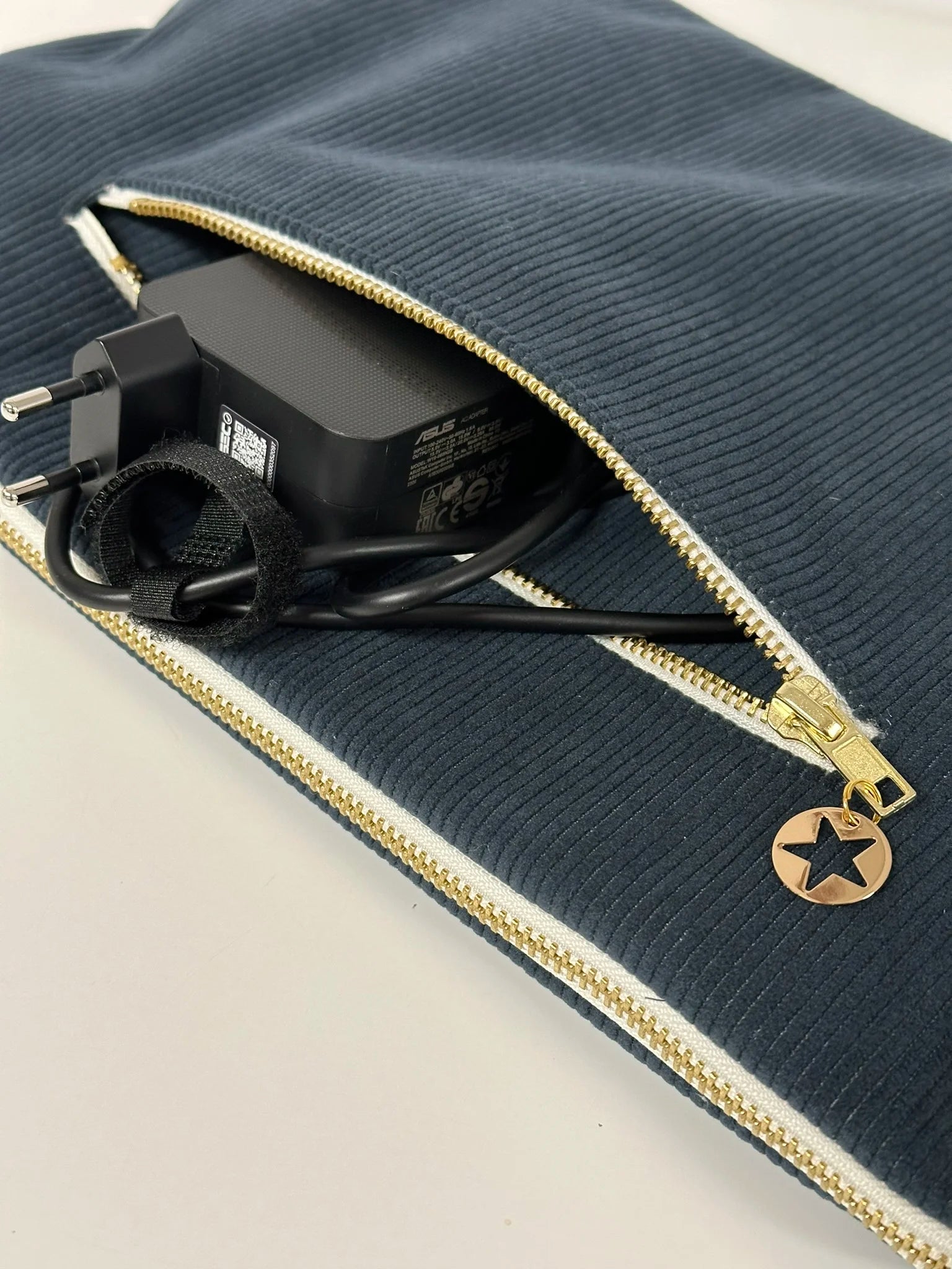 La poche chargeur zippée de la pochette ordinateur en velours cotelé bleu canard.