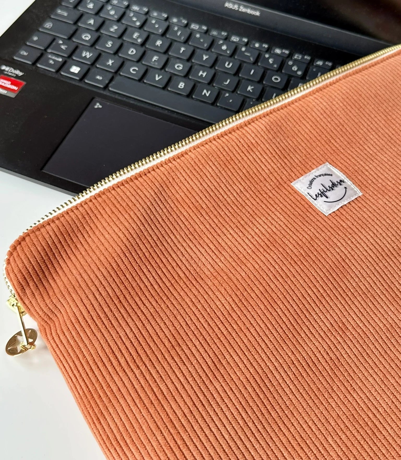Face avant de la pochette ordinateur en velours côtelé orange.