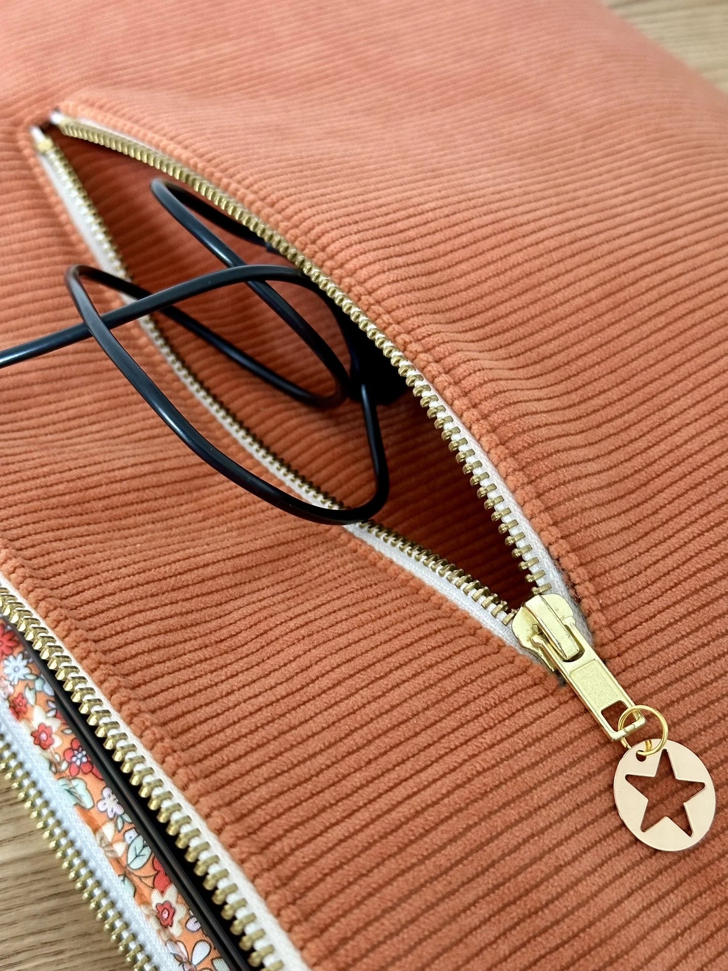 La poche zippée arrière de la pochette ordinateur en velours côtelé orange.