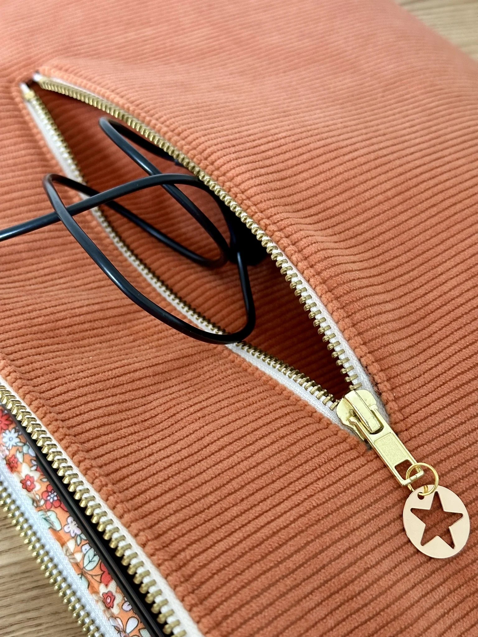 La poche zippée arrière de la pochette ordinateur en velours côtelé orange.