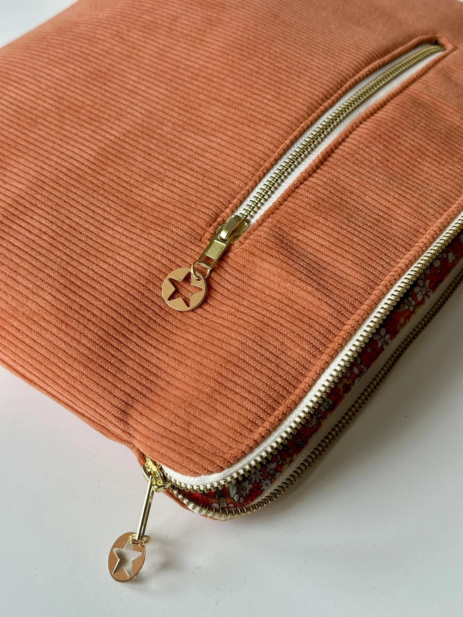 Vue détaillée de la pochette ordinateur en velours côtelé orange.