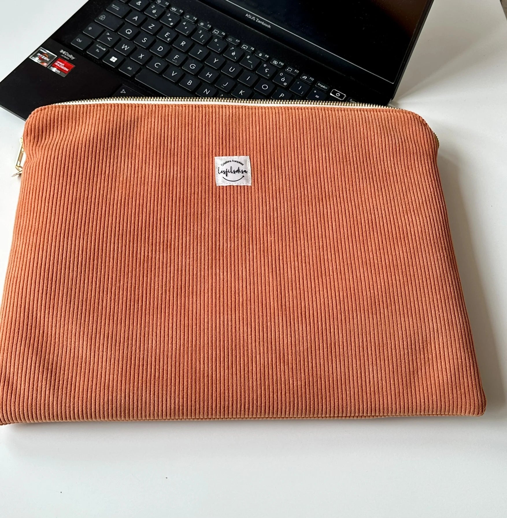 Vue d'ensemble de la pochette ordinateur en velours côtelé orange.