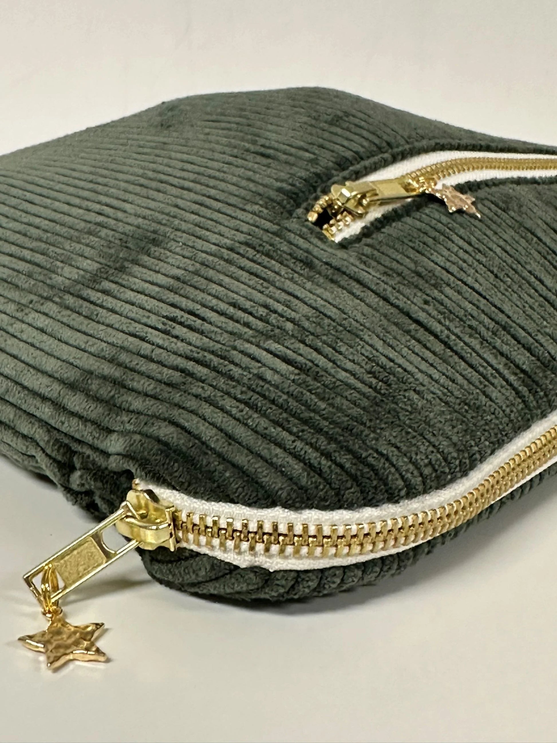 Vue détaillée de la fermeture zippée de la pochette ordinateur en velours cotelé vert kaki.