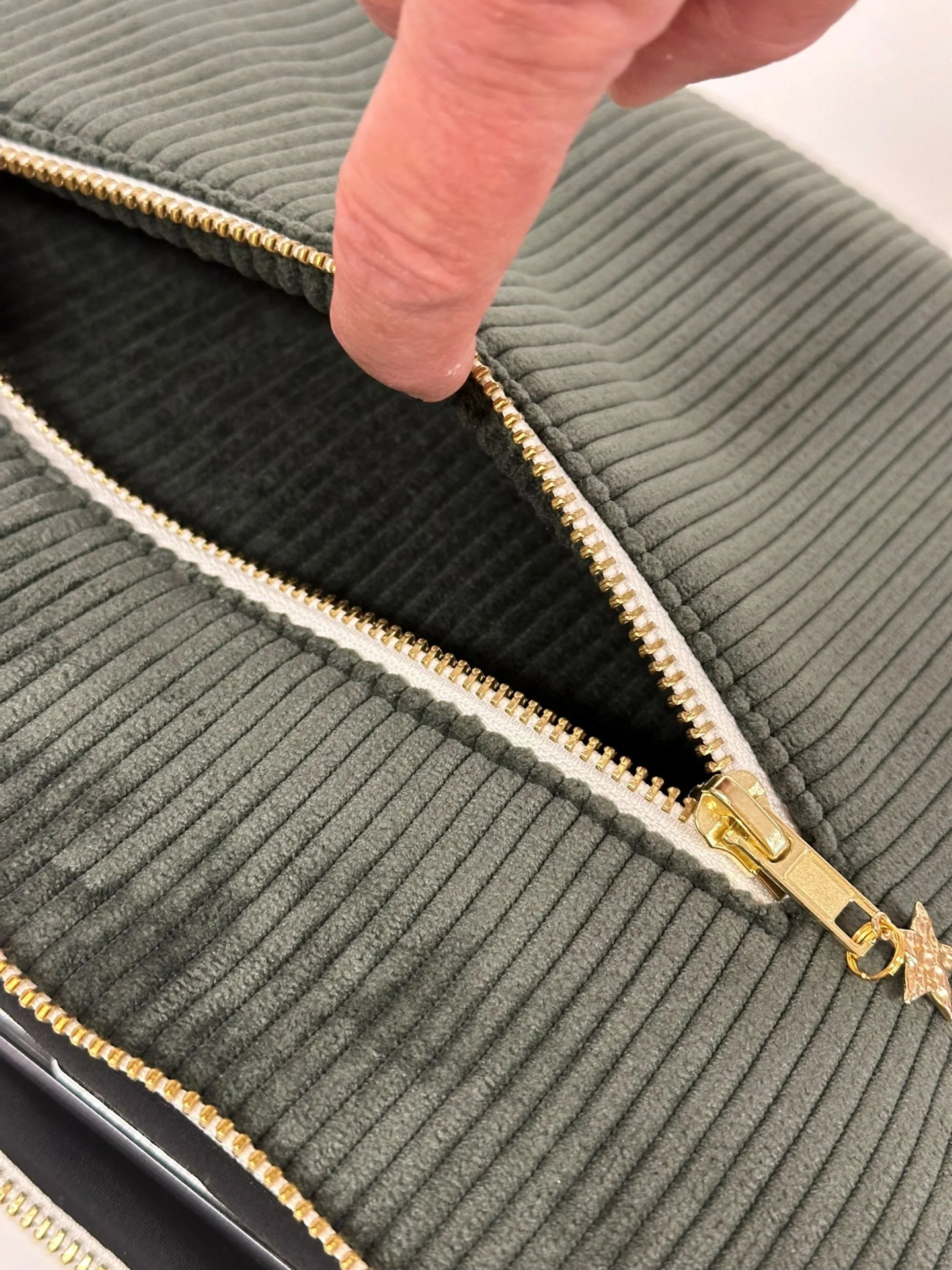 La poche arrière séparée de la pochette ordinateur en velours cotelé vert kaki.