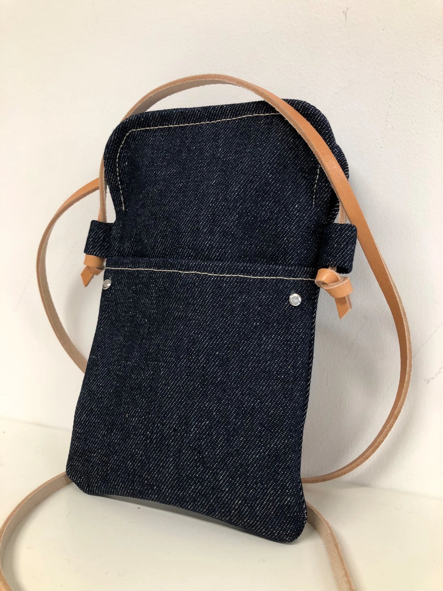 La pochette téléphone bandoulière Lesfilsdisa en denim brut et cuir naturel
