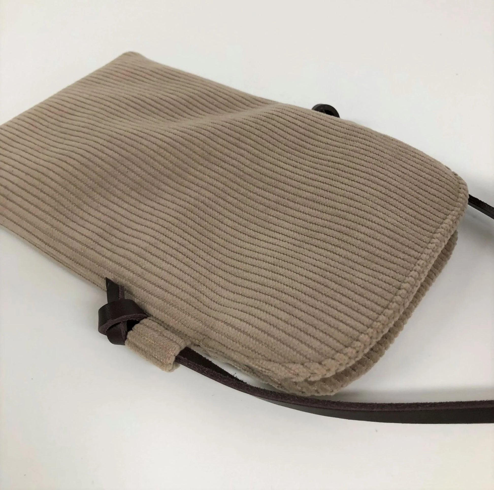 Le dos de la pochette téléphone bandoulière en velours cotelé beige.