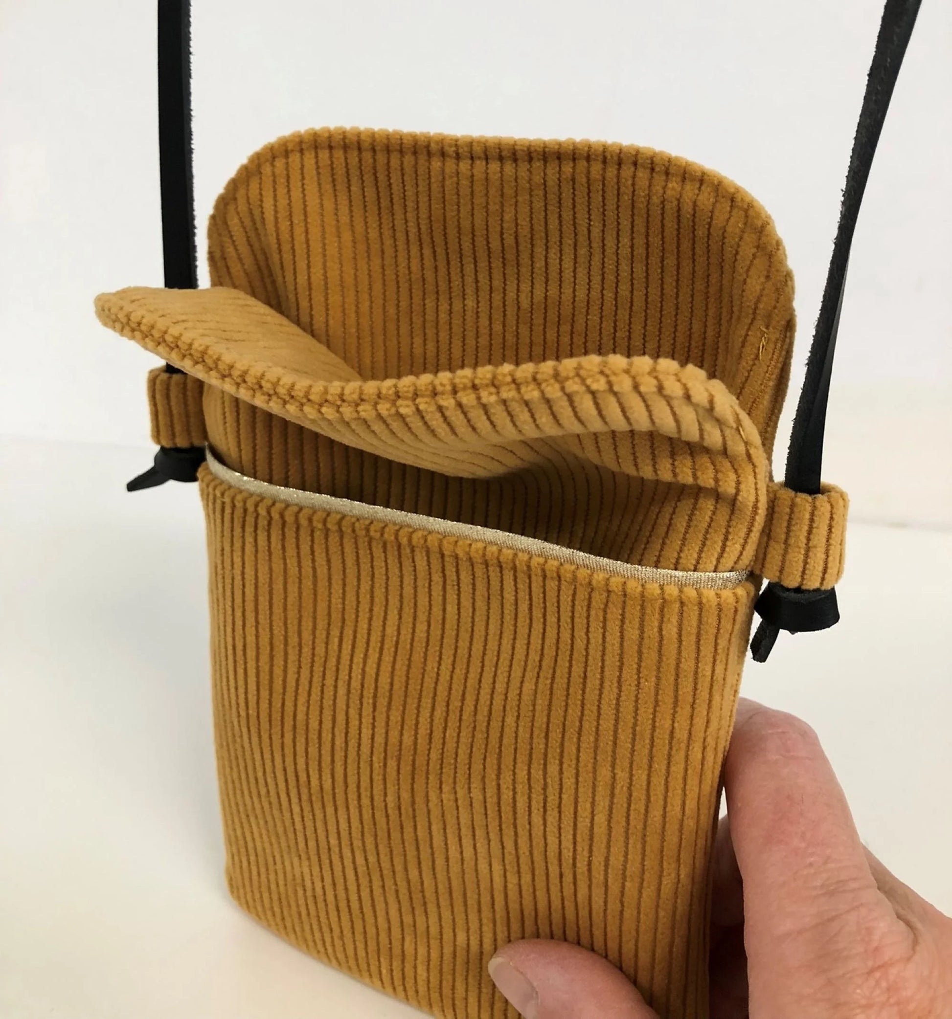 L'intérieur de la pochette téléphone bandoulière en velours cotelé jaune moutarde.