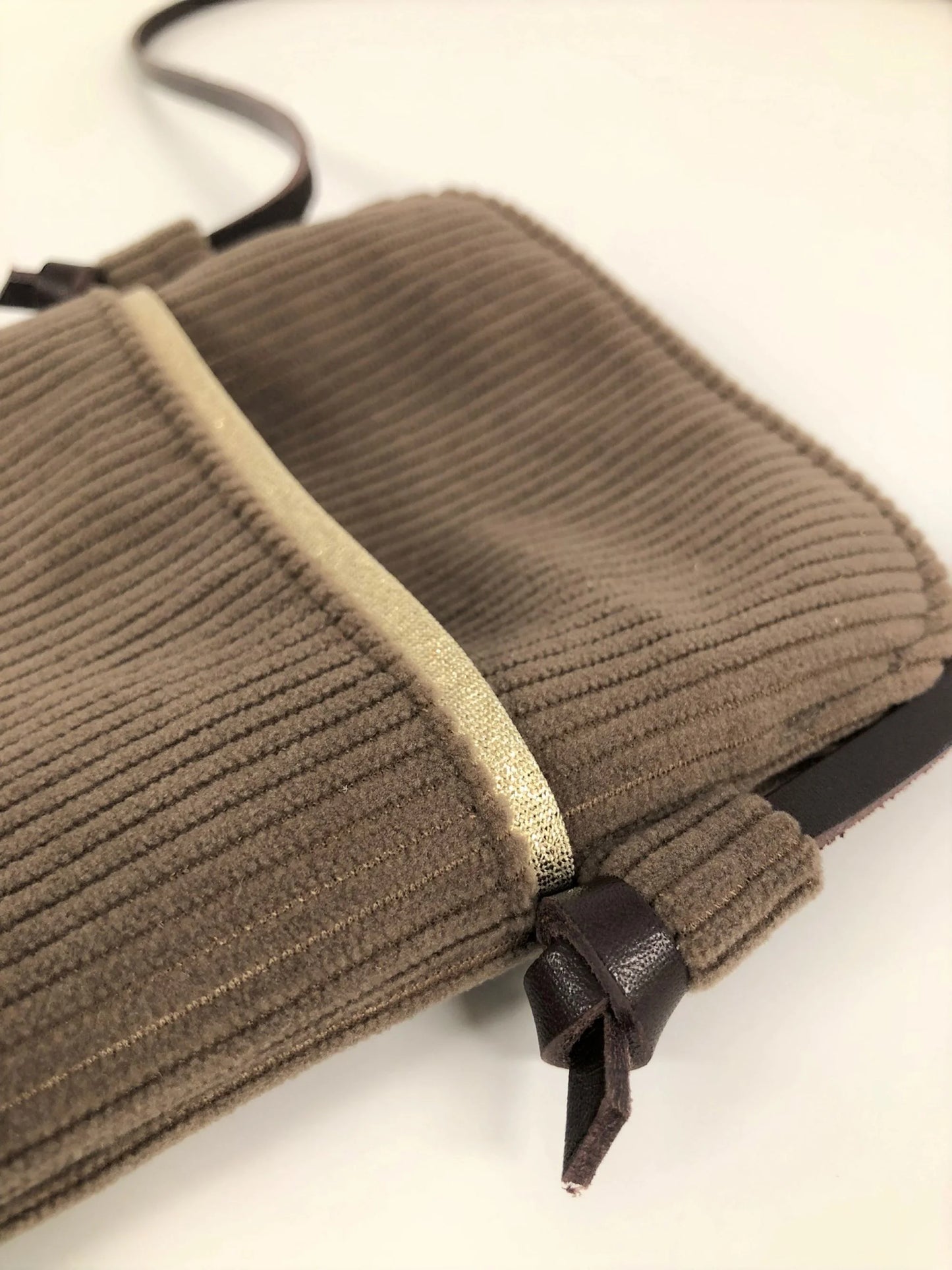 Vue de détail de la pochette téléphone bandoulière en velours côtelé marron chamois et cuir marron