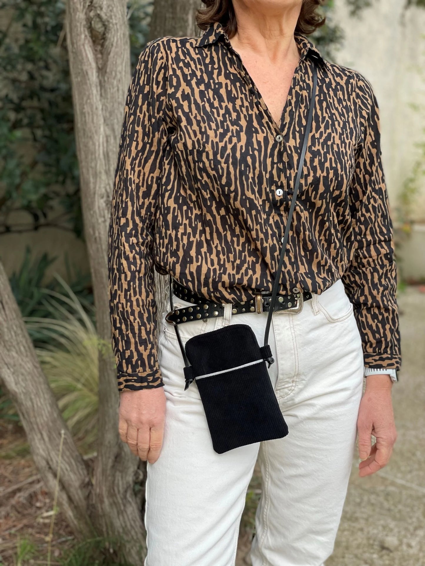 La pochette téléphone en velours côtelé noir et cuir noir, portée