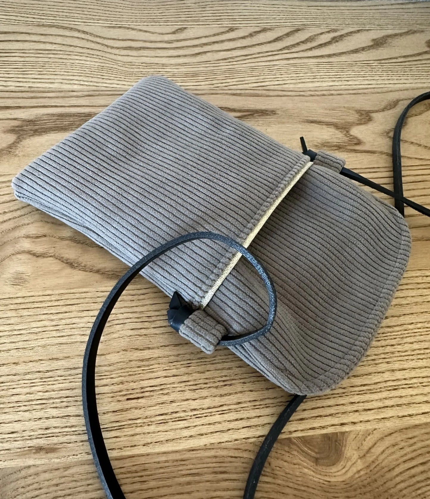 La poche avant de la pochette téléphone en velours cotelé taupe .