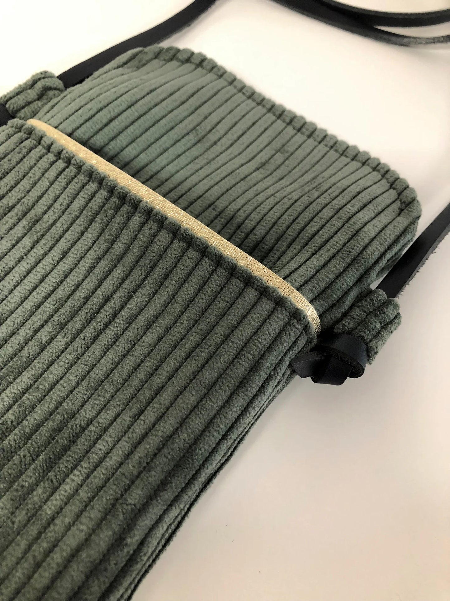 La poche avant de La pochette téléphone bandoulière en velours côtelé vert kaki et cuir