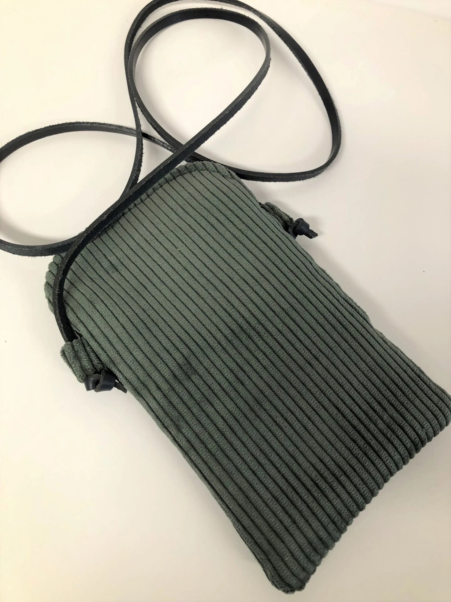 Le dos de La pochette téléphone bandoulière en velours côtelé vert kaki et cuir