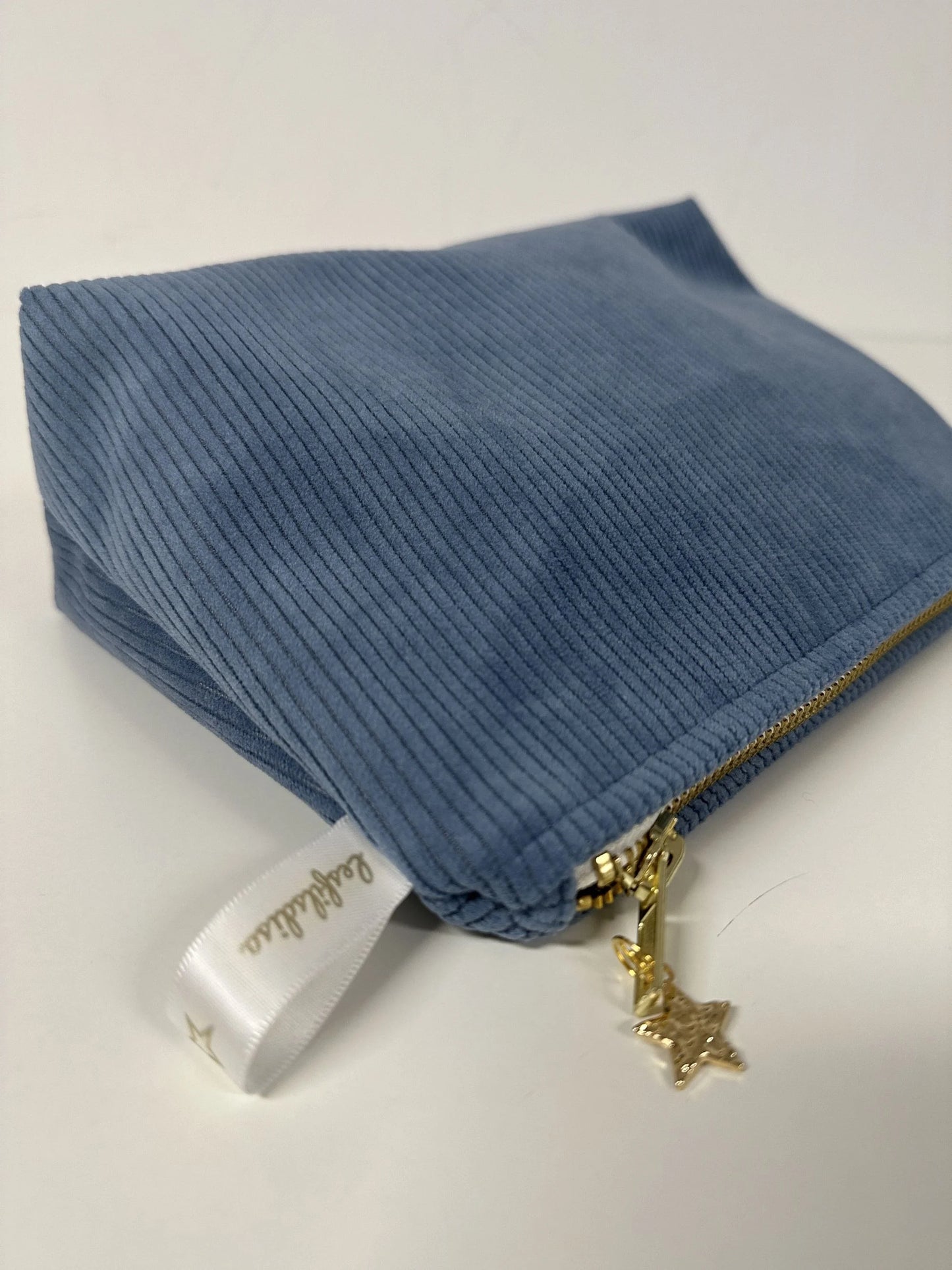 La pochette en velours côtelé bleu azur.