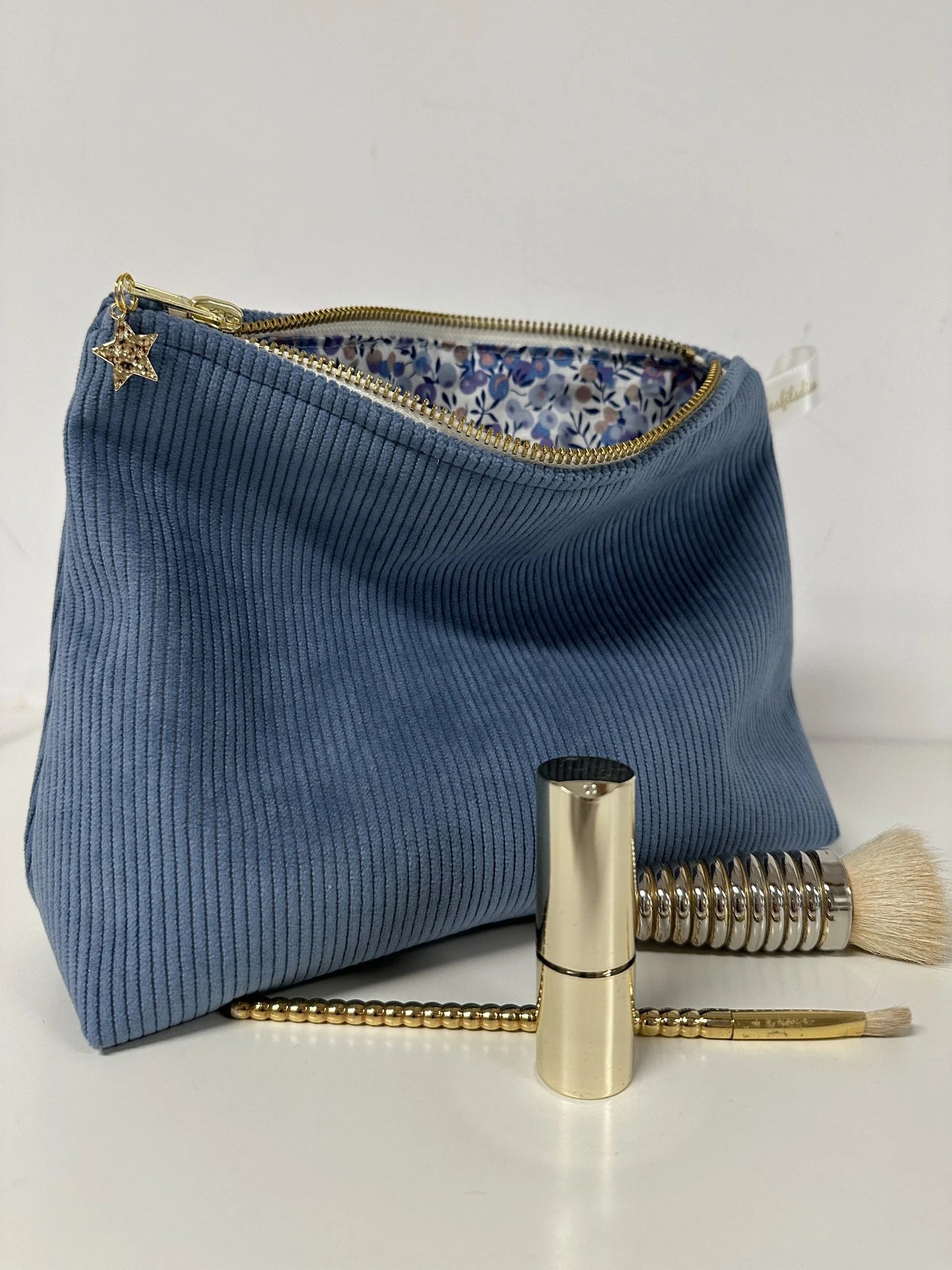 La pochette en velours côtelé bleu azur, ouverte.
