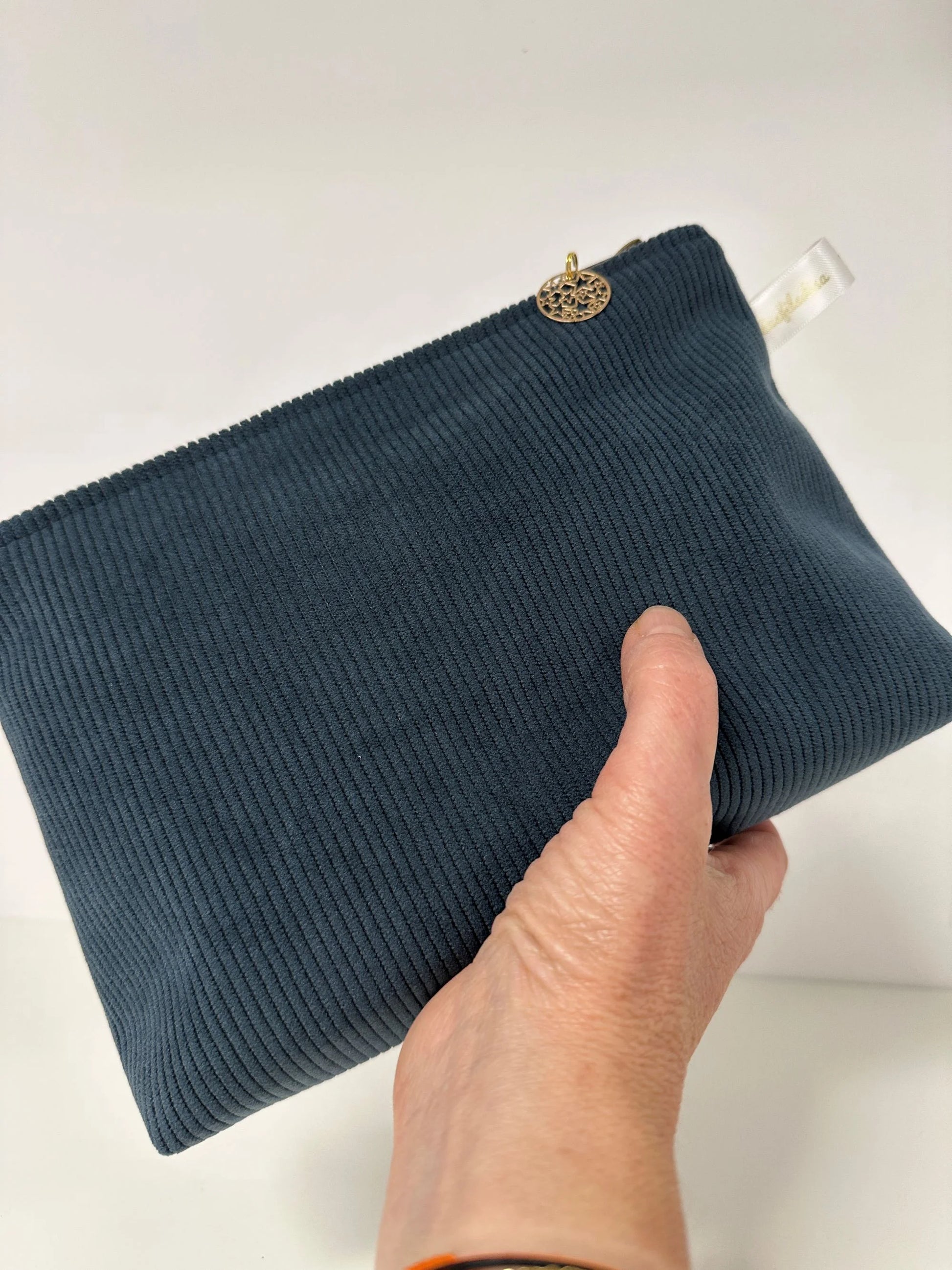 La pochette en velours côtelé bleu canard Lesfilsdisa en main