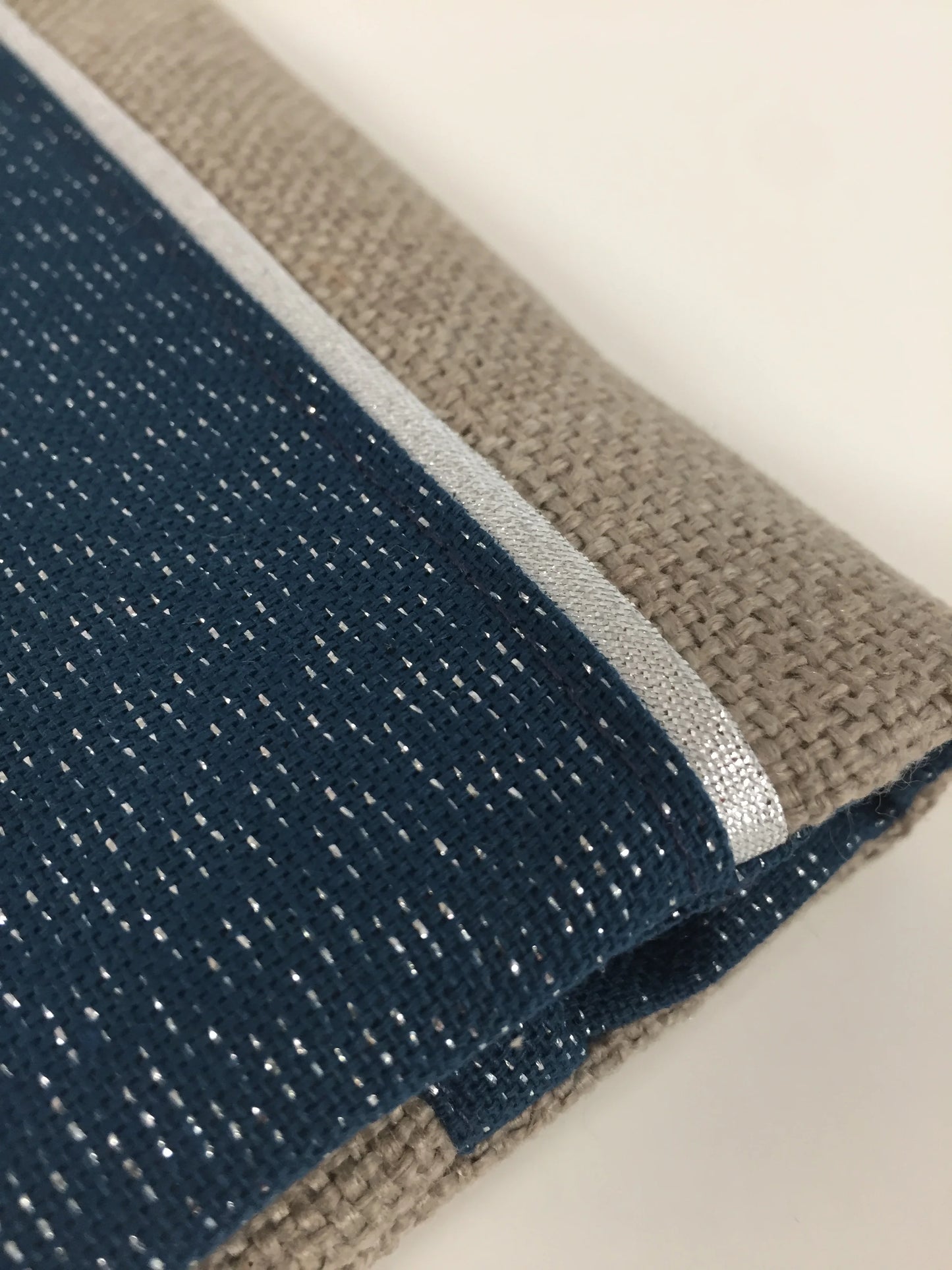 Vue détaillée du porte-chéquier beige et bleu marine pailleté à liseré argenté.