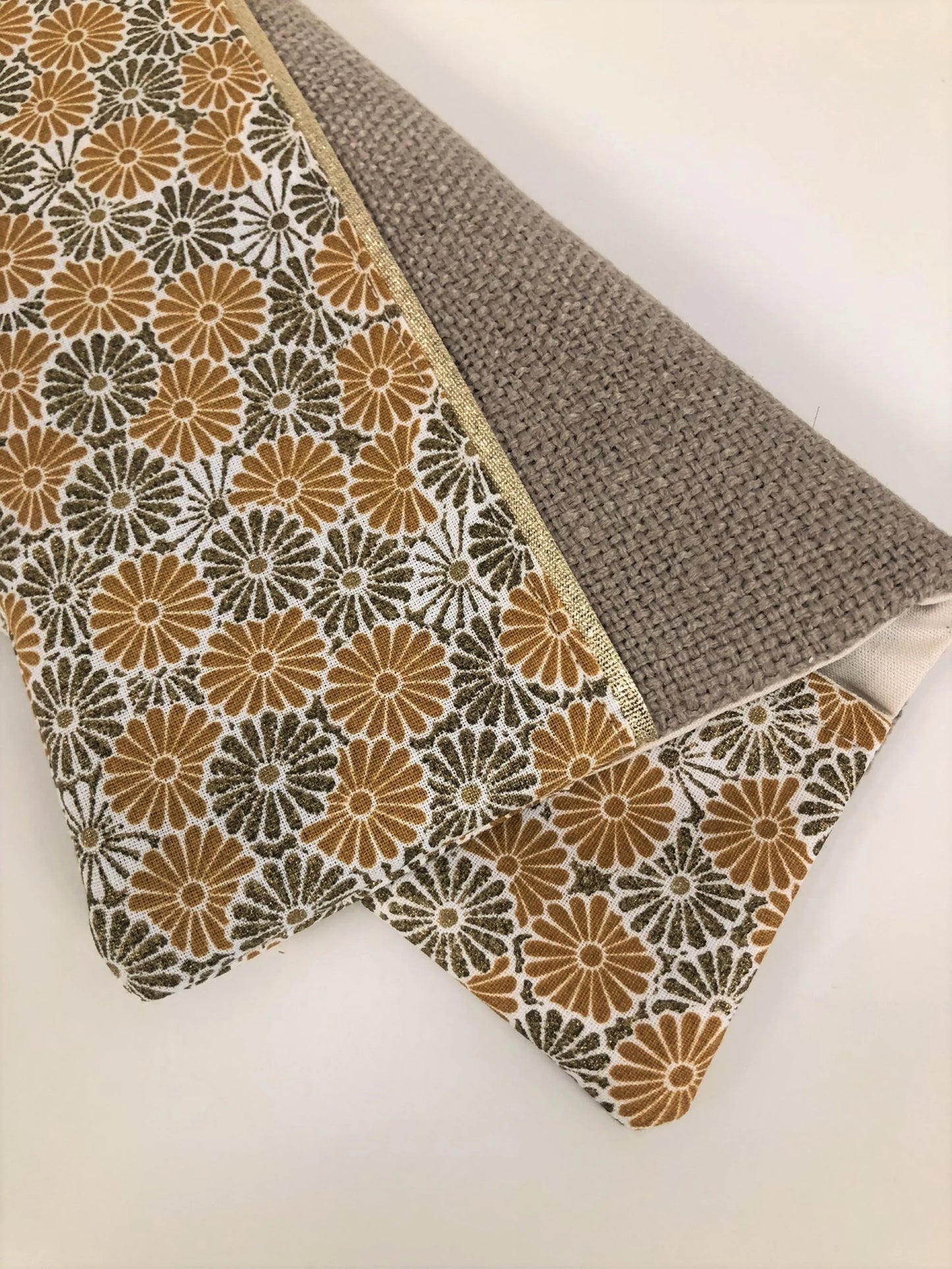 Le porte-chéquier beige à fleurs moutarde et bronze, vide.