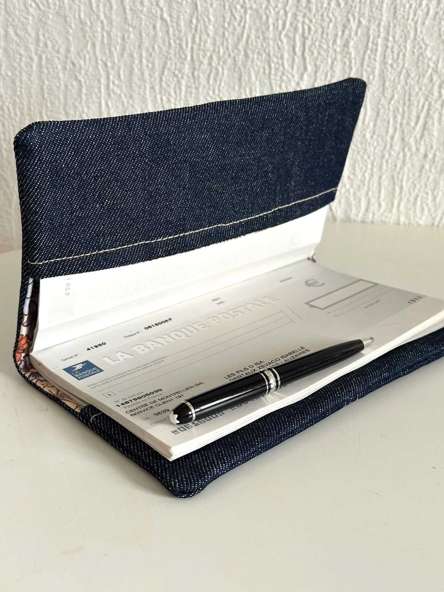 Le porte chéquier en denim ouvert.