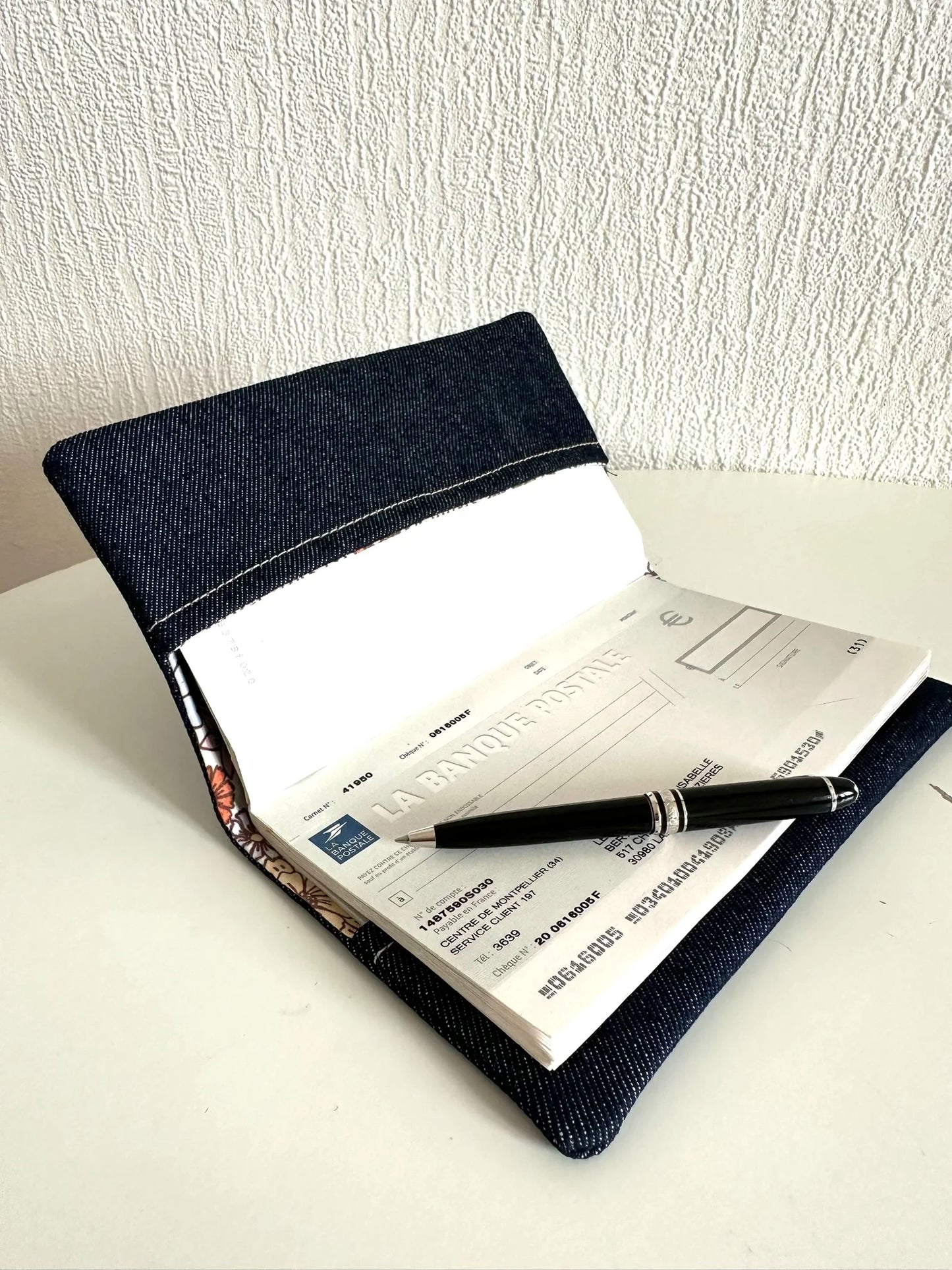 Le porte chéquier en denim avec carnet de chèques à talon haut.