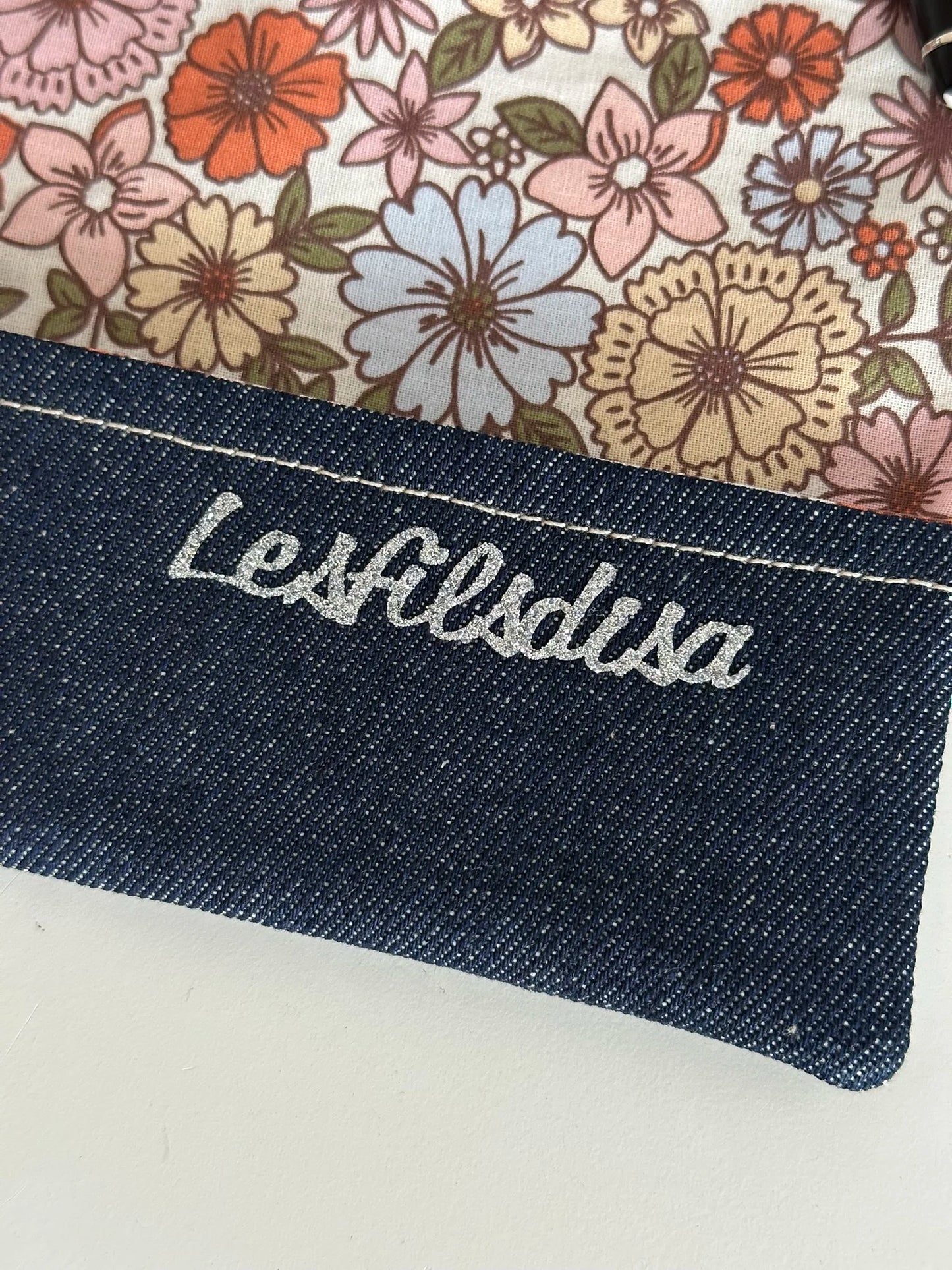 Le rabat inférieur et la doublure fleurie du porte chéquier en denim.