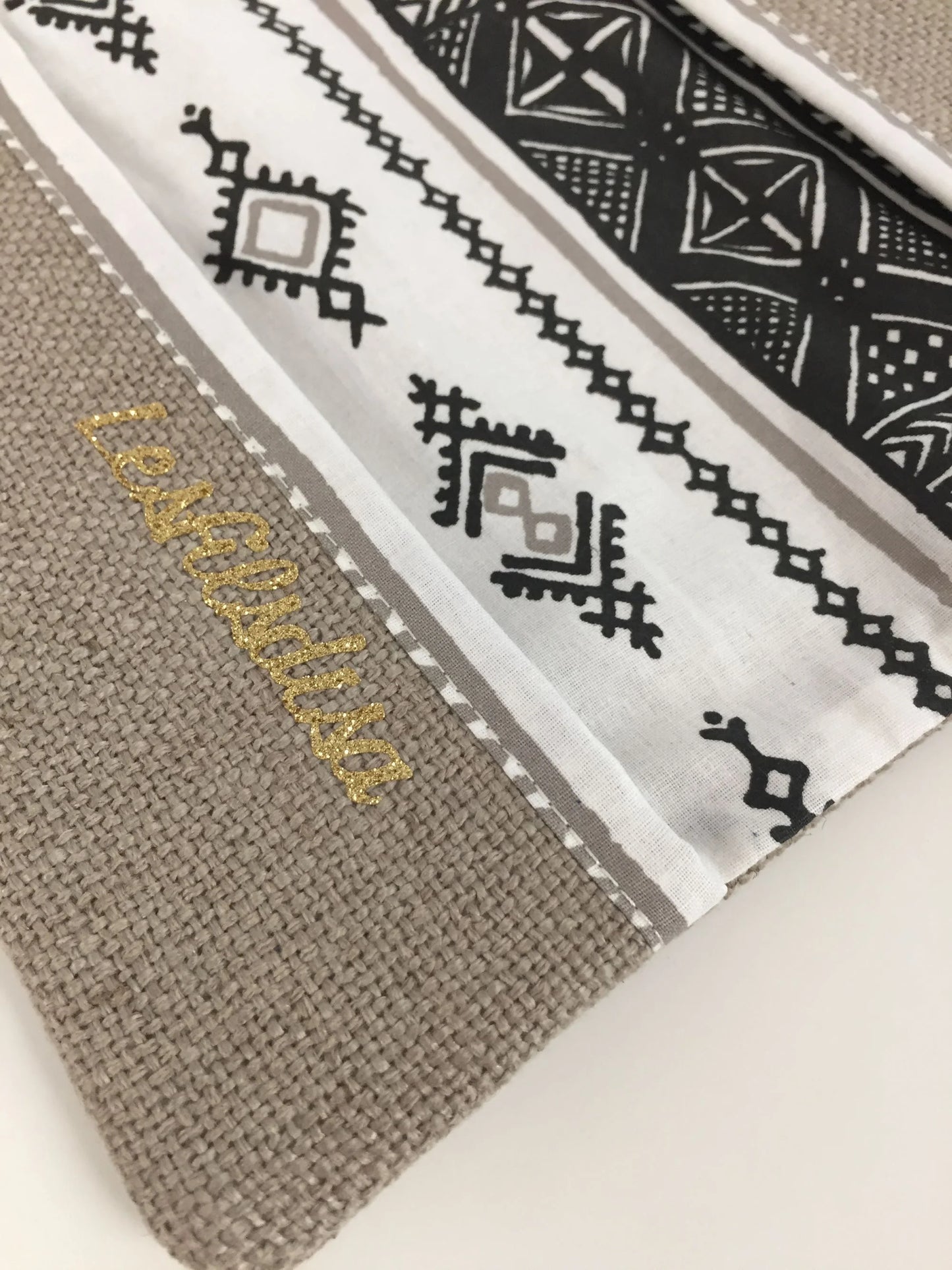 Le fond du porte-chéquier ethnique beige, blanc et doré.