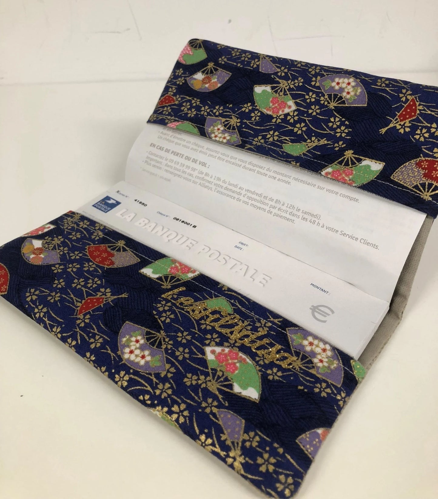 Le porte-chéquier en lin beige et tissu japonais bleu éventails, ouvert.