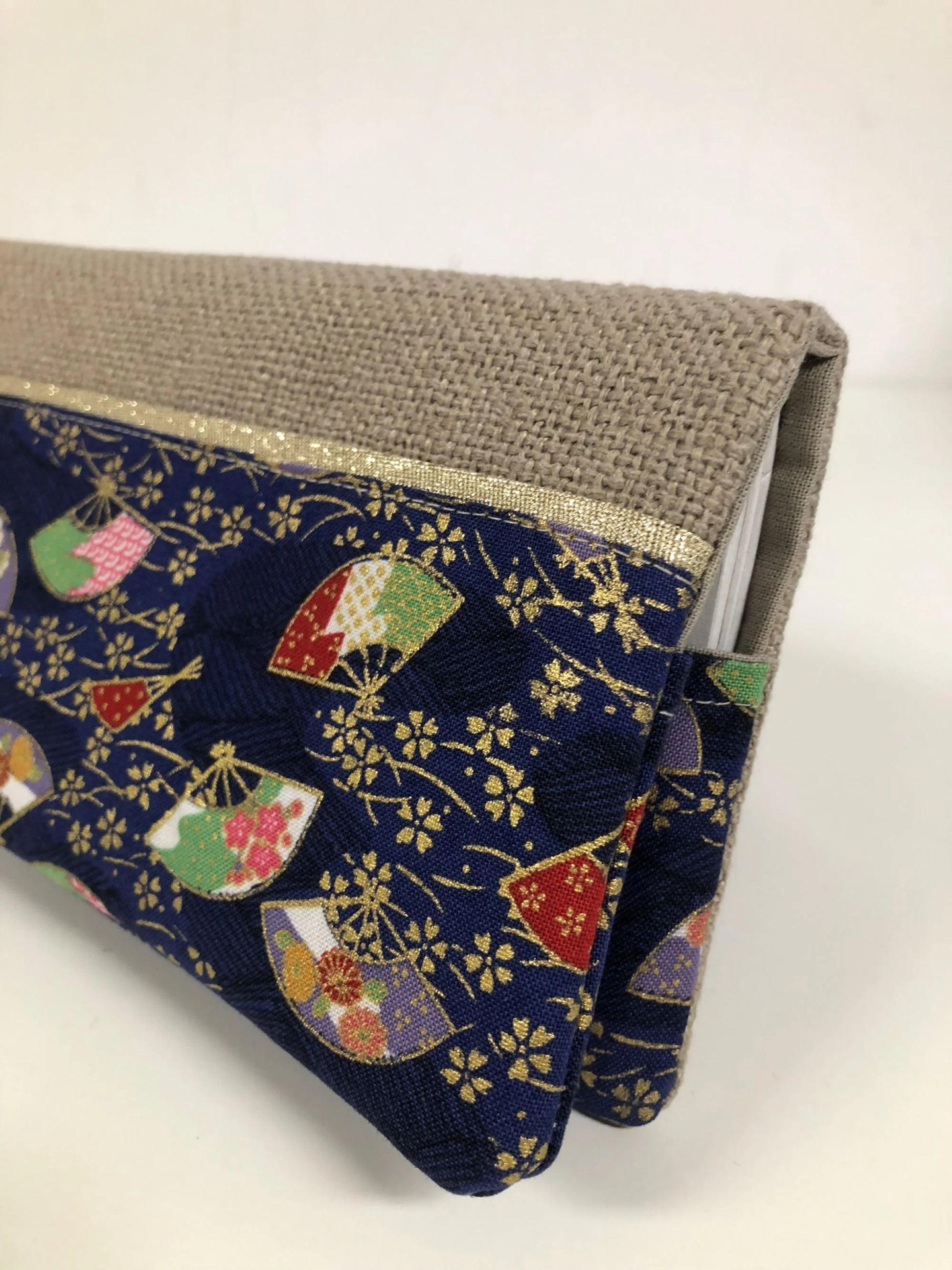 Vue détaillée du porte-chéquier en lin beige et tissu japonais bleu éventails.