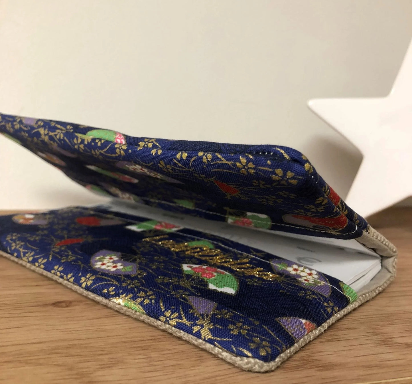 Le porte-chéquier en lin beige et tissu japonais bleu éventails, entrouvert.