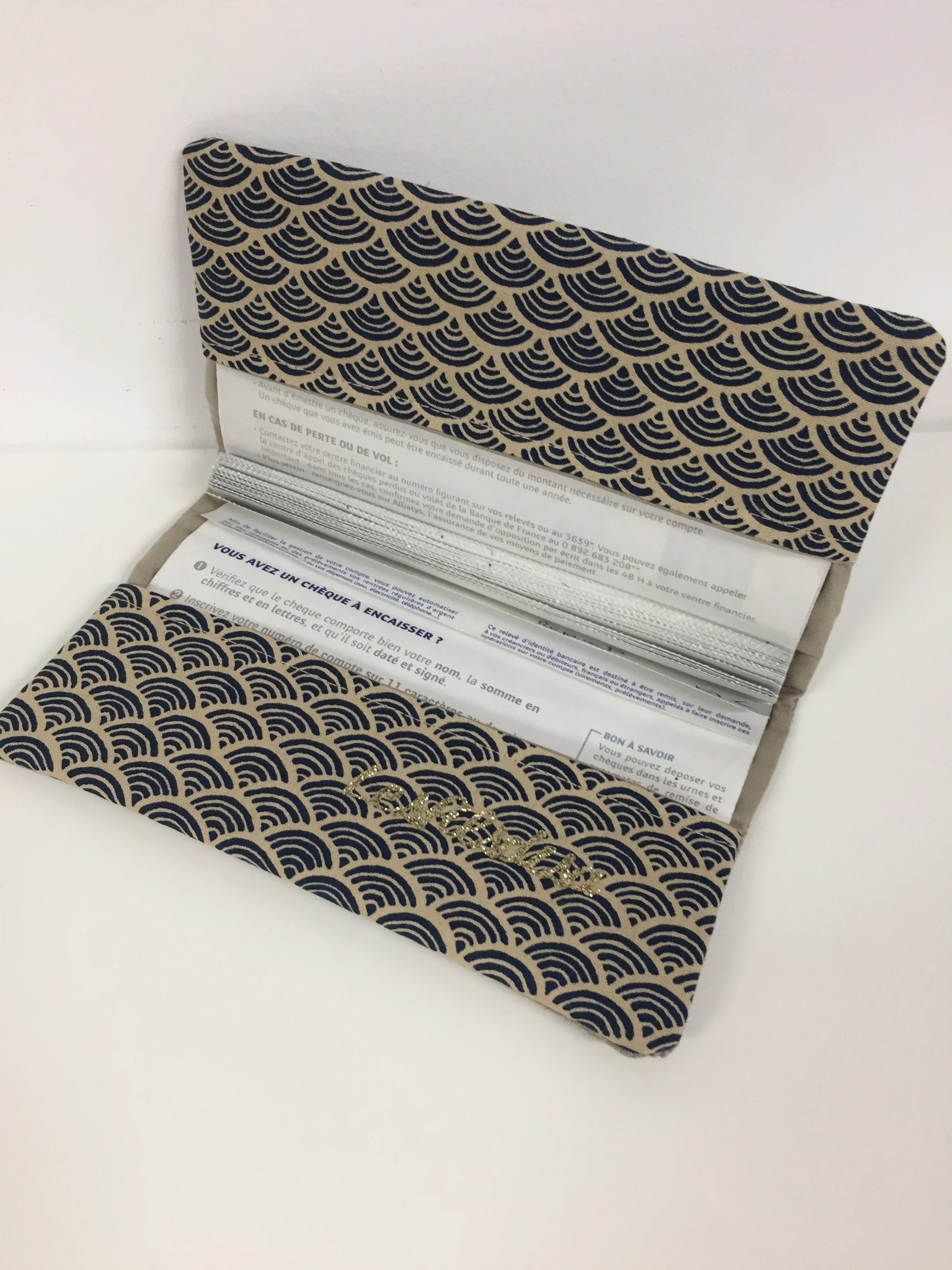 Le porte chéquier en lin beige et tissu japonais Seigaiha bleu marine, ouvert.