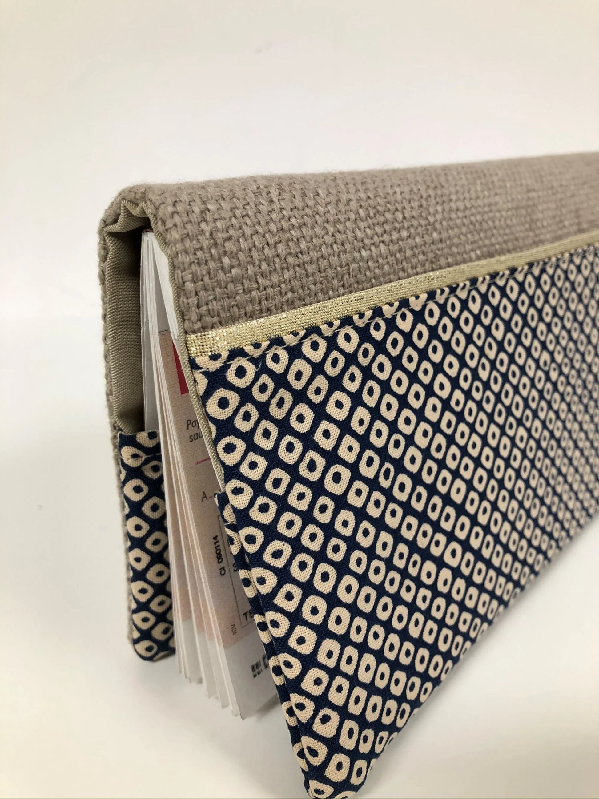 Vue détaillée du porte-chéquier en lin beige et tissu japonais Shibori bleu.