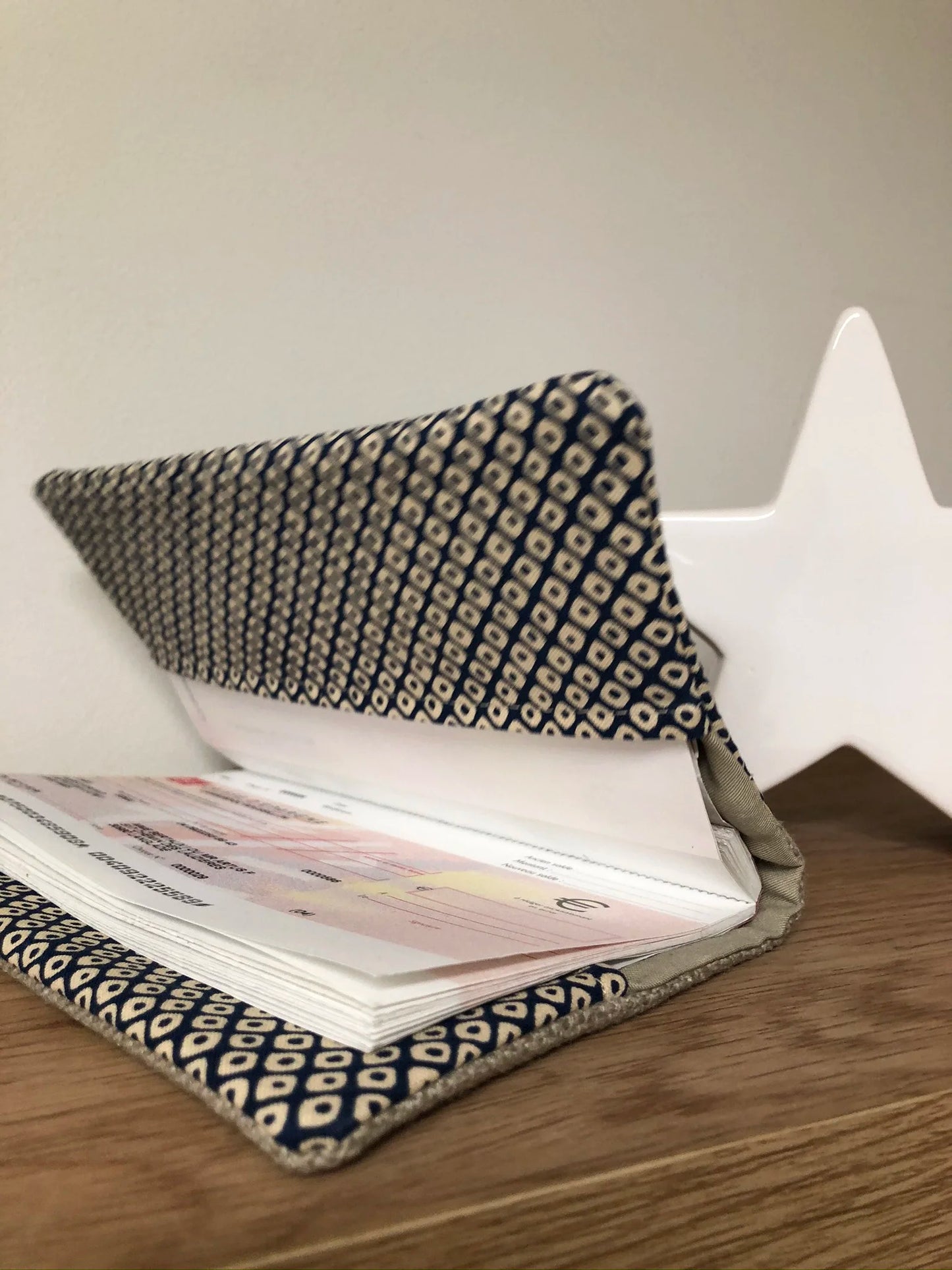 Le porte-chéquier en lin beige et tissu japonais Shibori bleu, entrouvert.