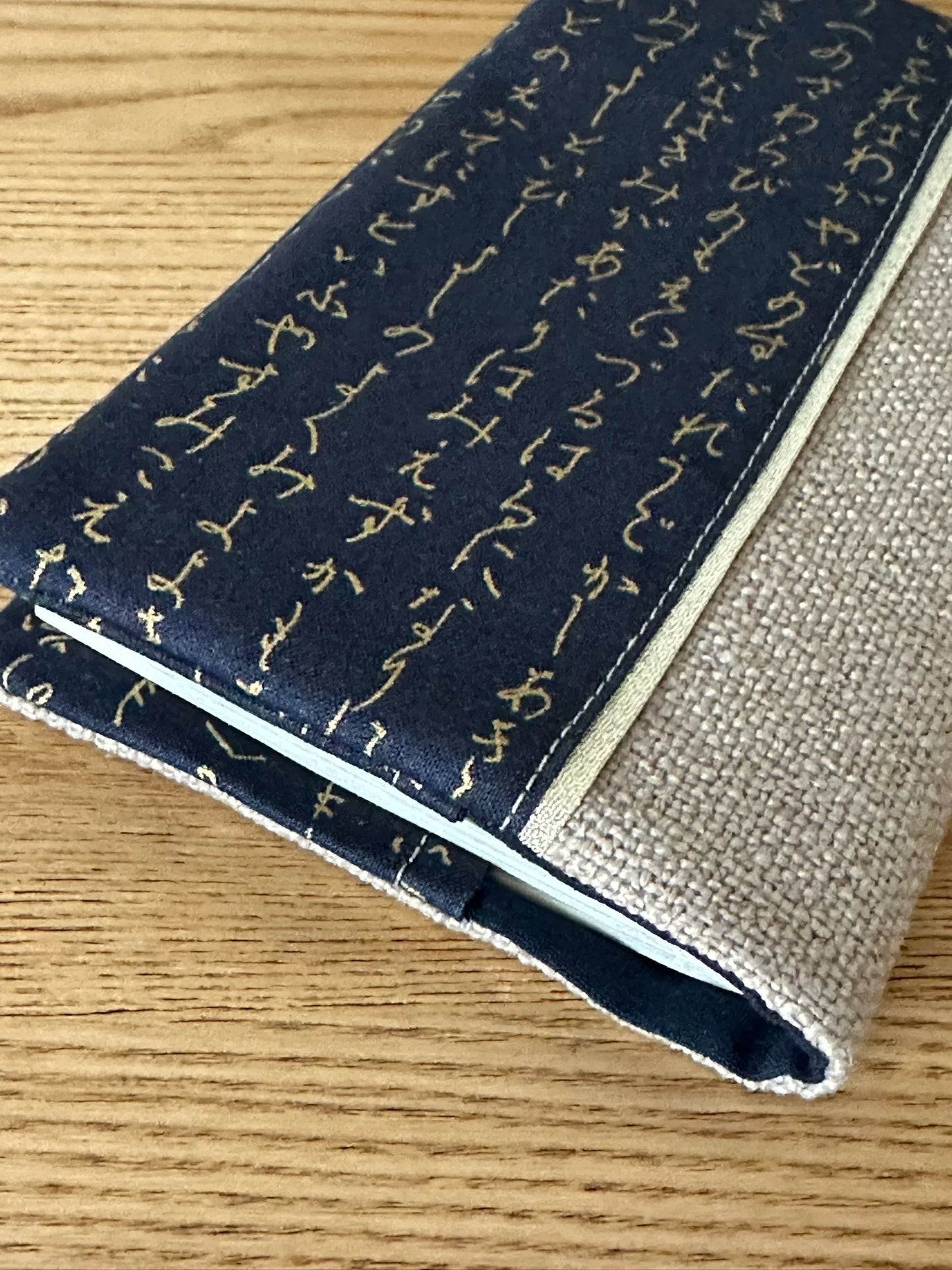 Vue détaillée du porte chéquier en lin et tissu japonais écriture dorée.