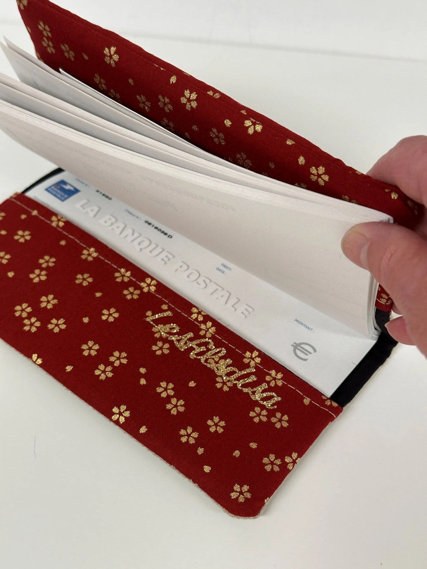 Le rabat inférieur du porte-chéquier en lin et tissu japonais Sakura rouge.