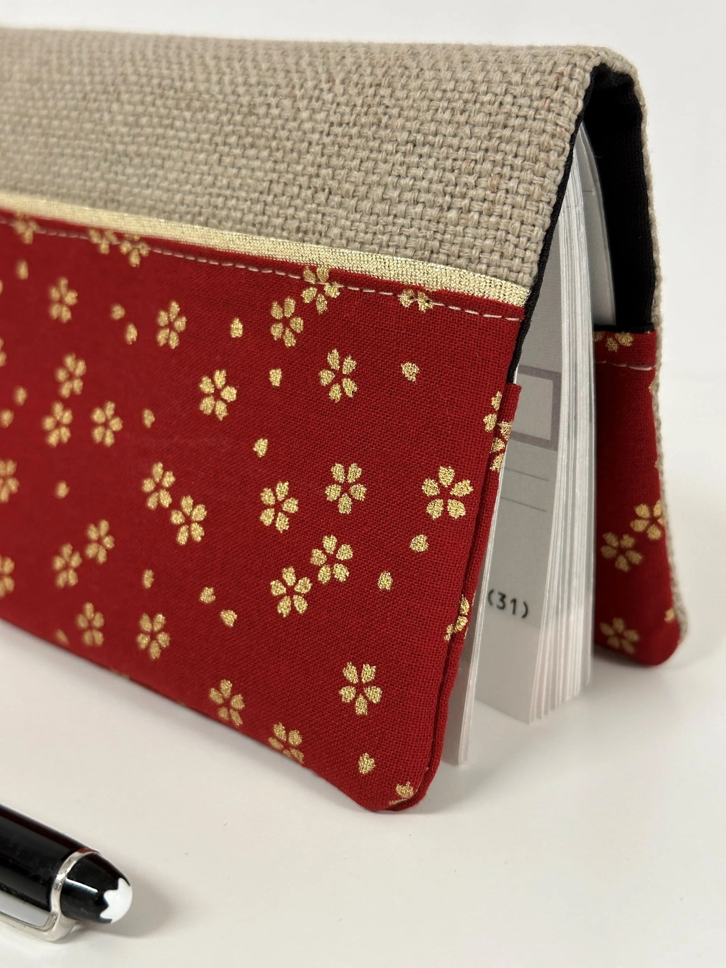 Le tissu japonais du porte-chéquier en lin et tissu japonais Sakura rouge.