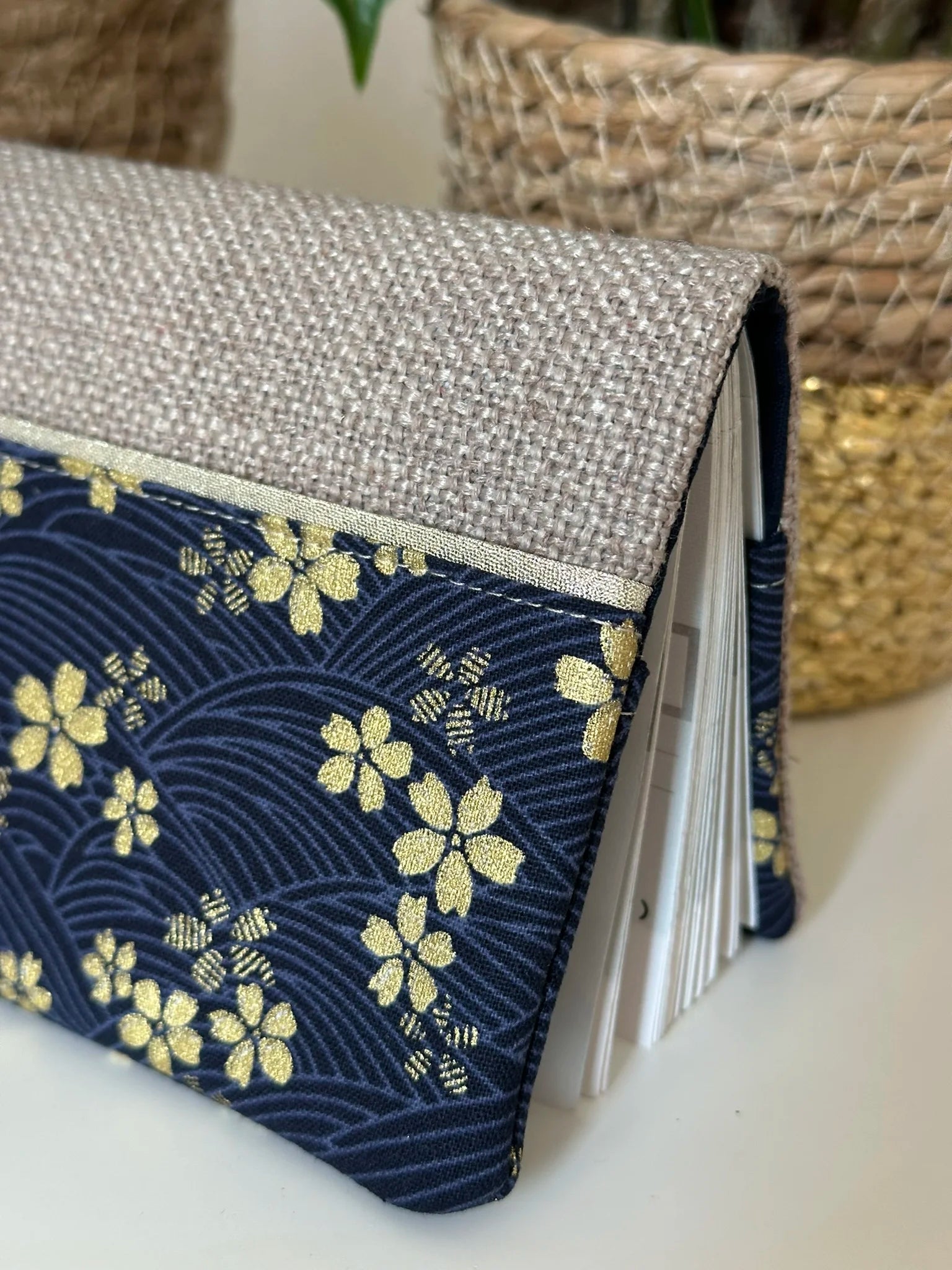 Les fleurs de cerisier dorées du porte chéquier en lin et tissu japonais Sakura bleu.
