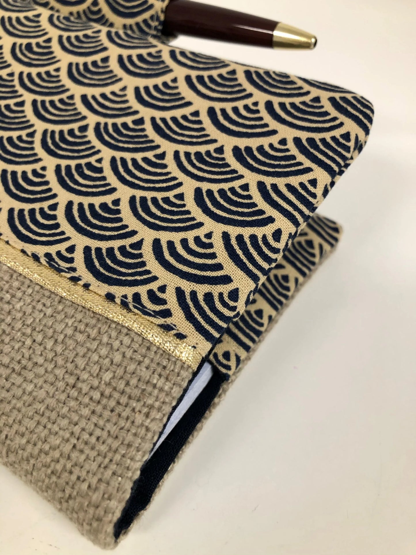 Vue détaillée de la face avant du porte-chéquier avec porte stylo en lin et tissu japonais Seigaiha.