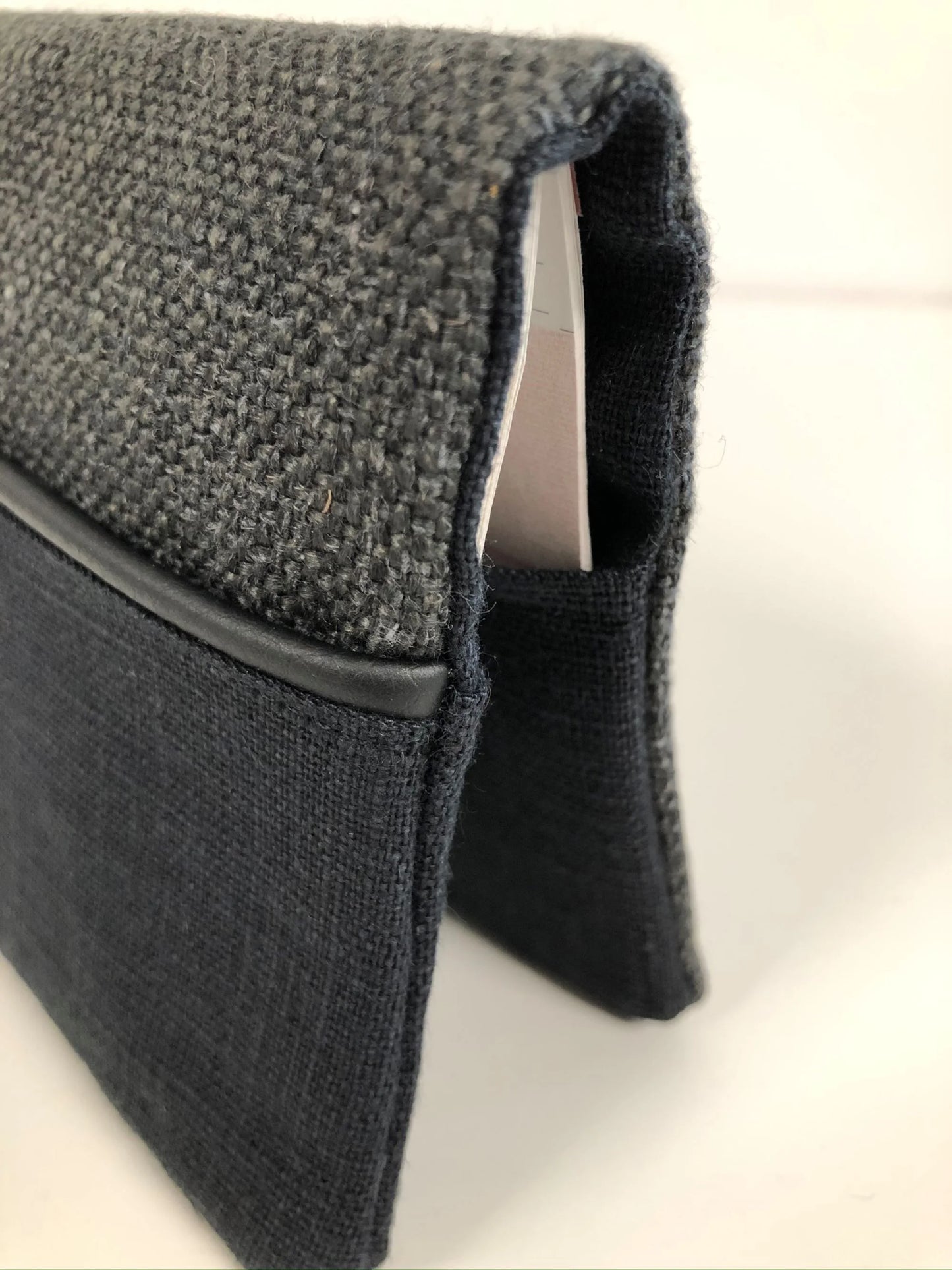 Le liseré noir du porte-chéquier unisexe en lin gris anthracite et noir.