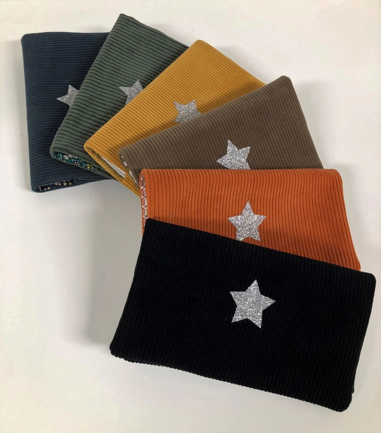 Exemples de coloris disponibles du porte chéquier en velours cotelé et son étoile pailletée.