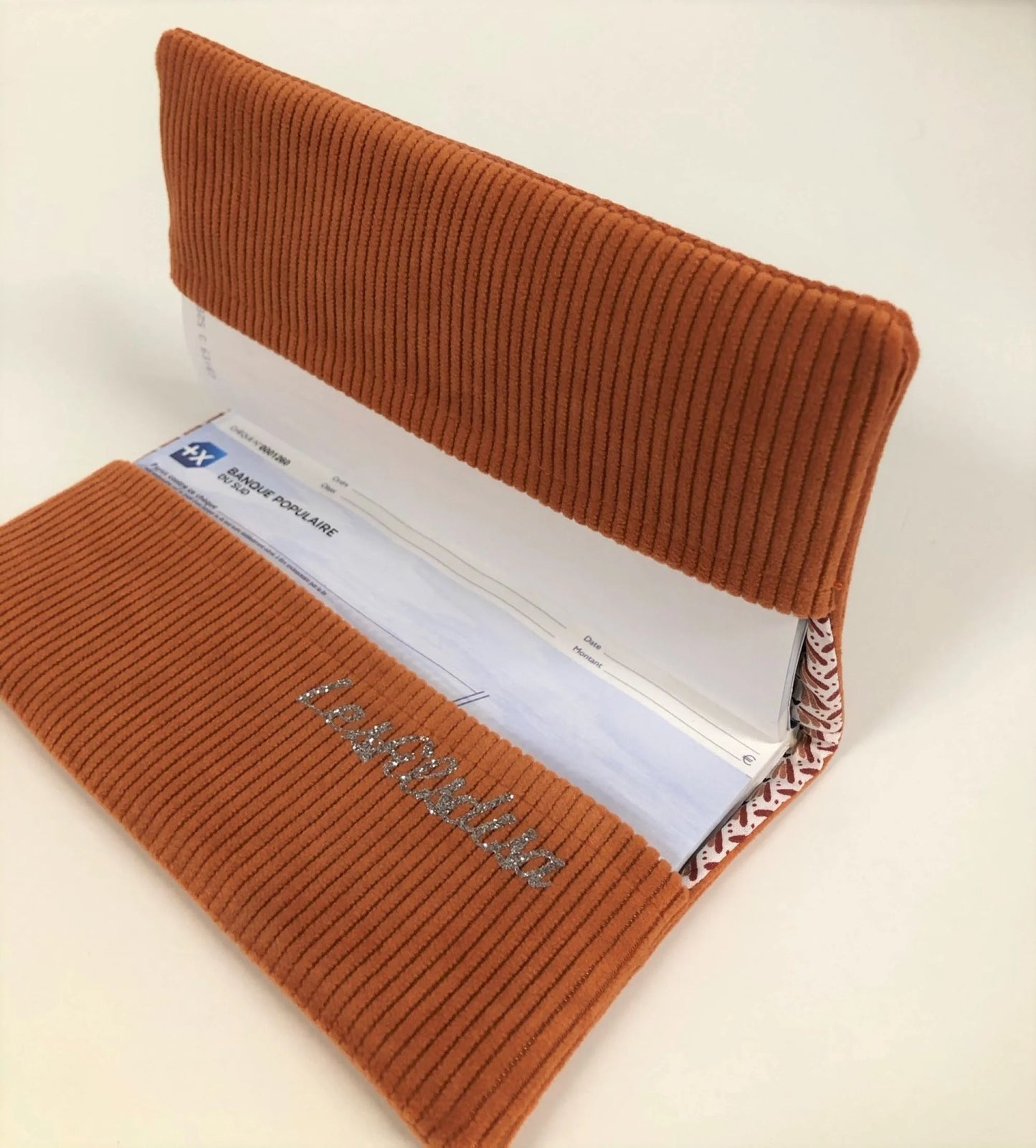 L'intérieur du porte chéquier en velours côtelé orange et son étoile pailletée argentée