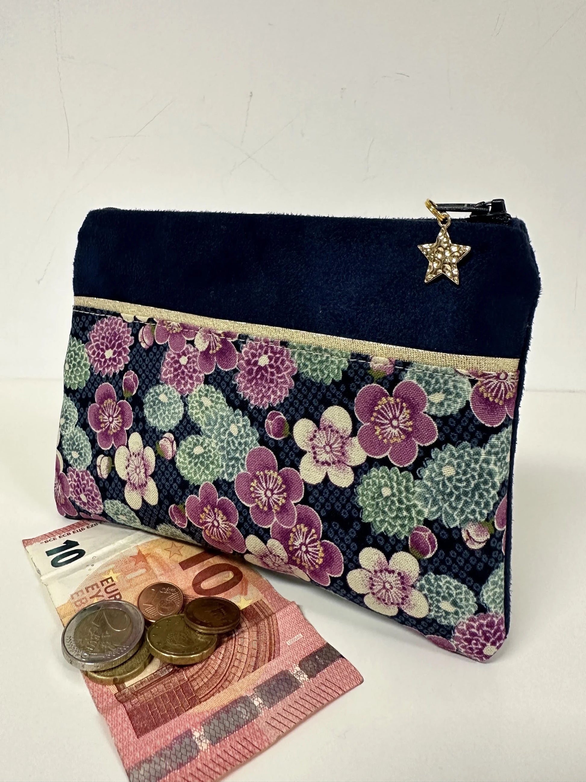 Le porte-monnaie bleu marine en tissu japonais à fleurs mauves, présenté avec pièces et billets.