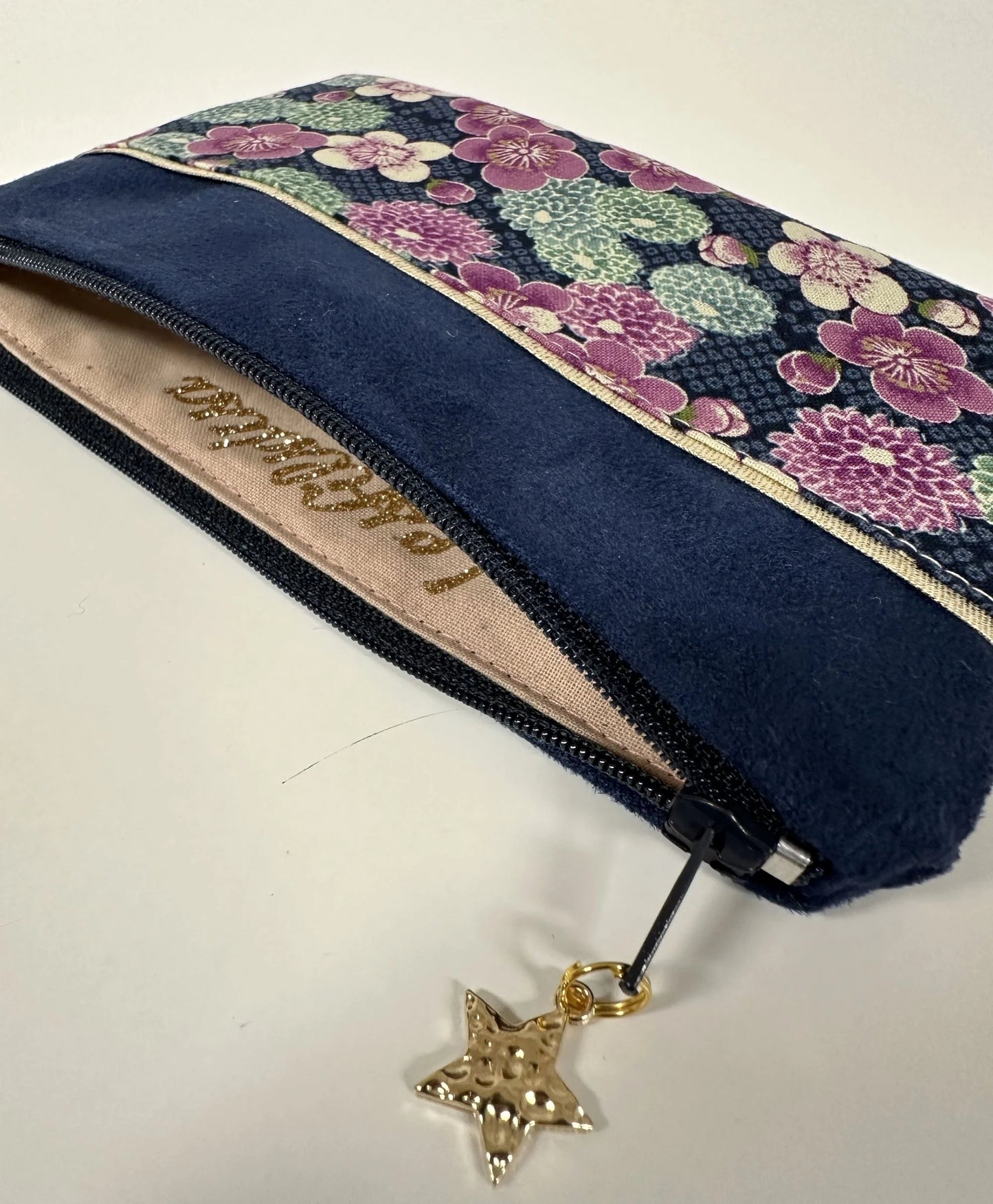 L'intérieur du porte-monnaie bleu marine en tissu japonais à fleurs mauves.