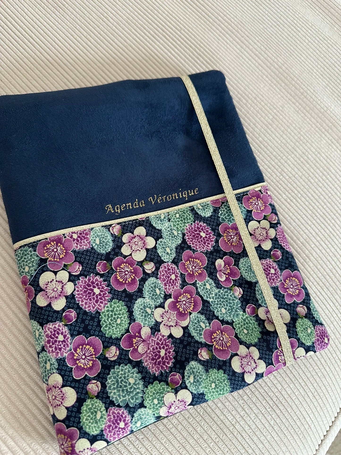 Exemple de personnalisation extérieure du protège agenda bleu marine en tissu japonais à fleurs mauves et dorées.
