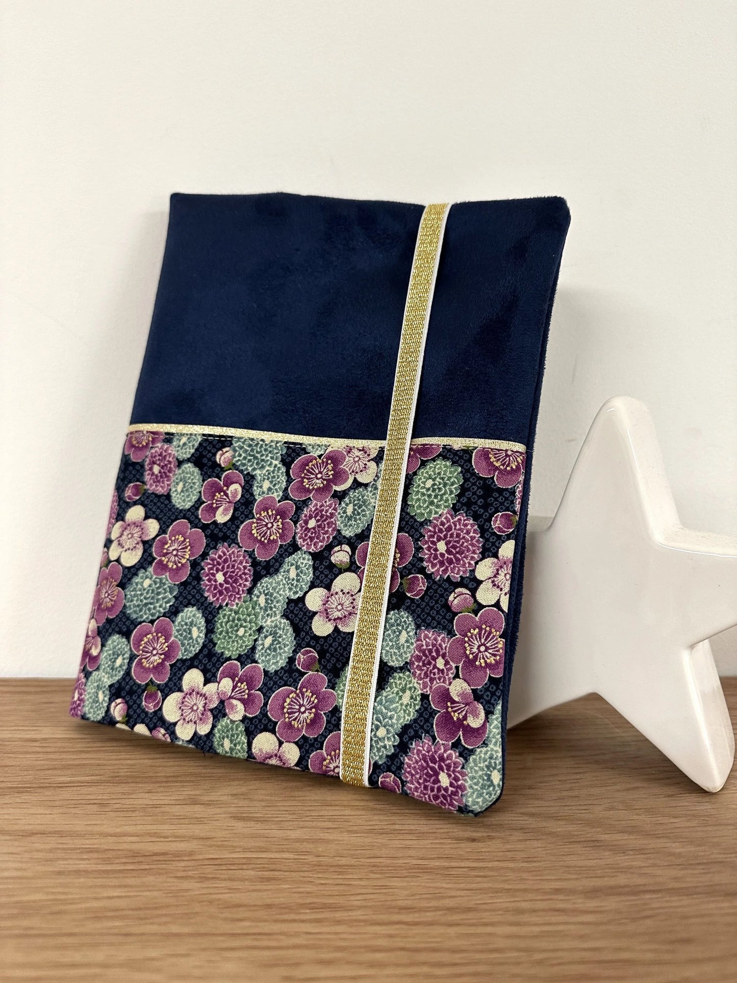 Le protège-agenda bleu marine en tissu japonais à fleurs mauves, fermé par son élastique doré.