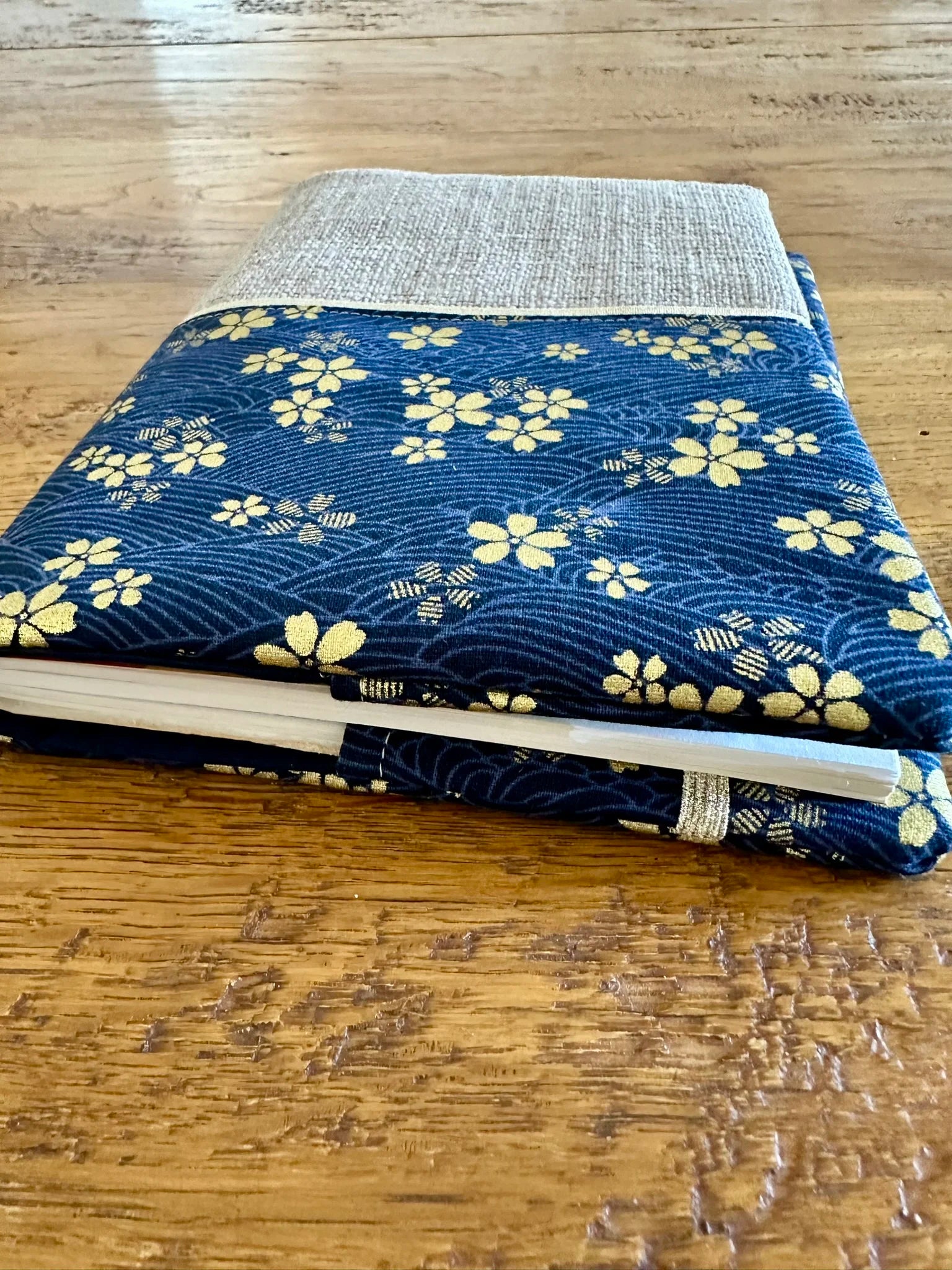 L'élastique doré placé à l'arrière du protège agenda en lin et tissu japonais Sakura bleu .