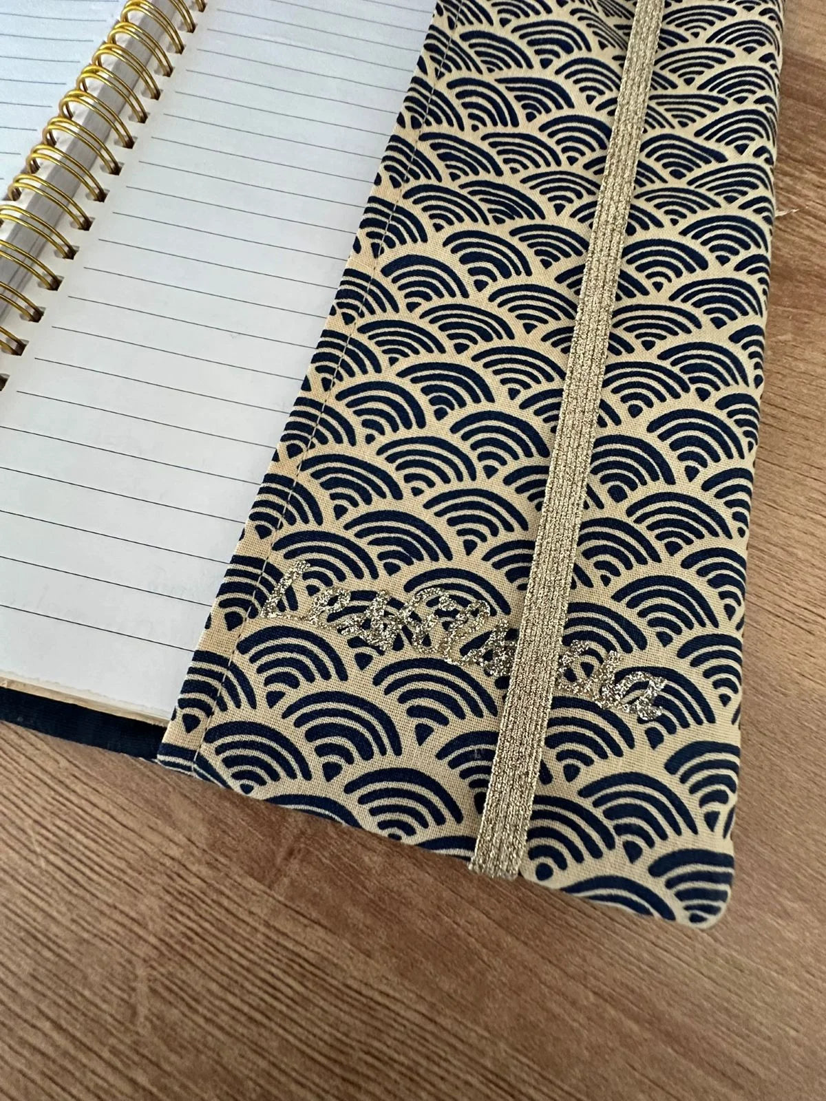 Le rabat inférieur du protège agenda en lin et tissu japonais Seigaiha bleu marine.