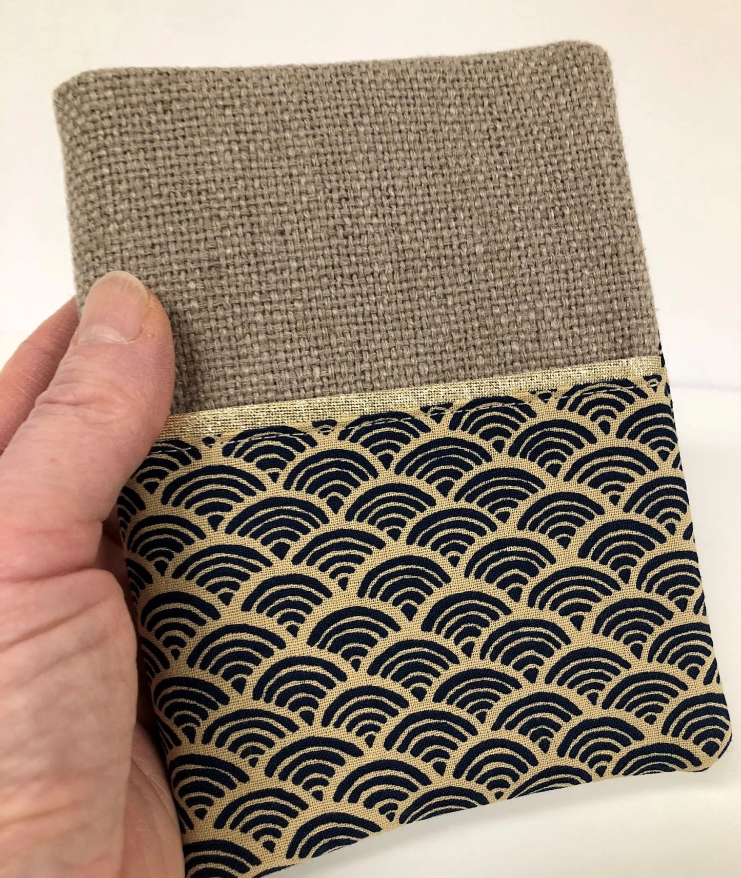 Le protège-agenda en lin et tissu japonais Seigaiha tenu en main.
