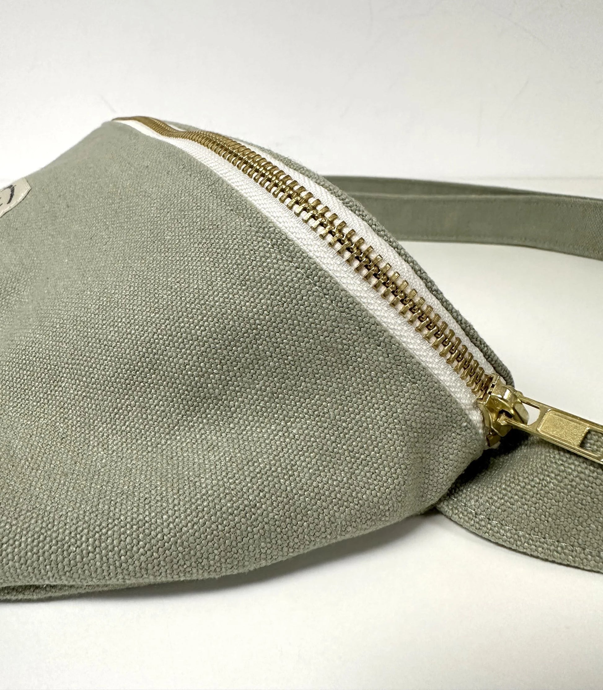 Vue de détail du sac banane en toile vert amande.