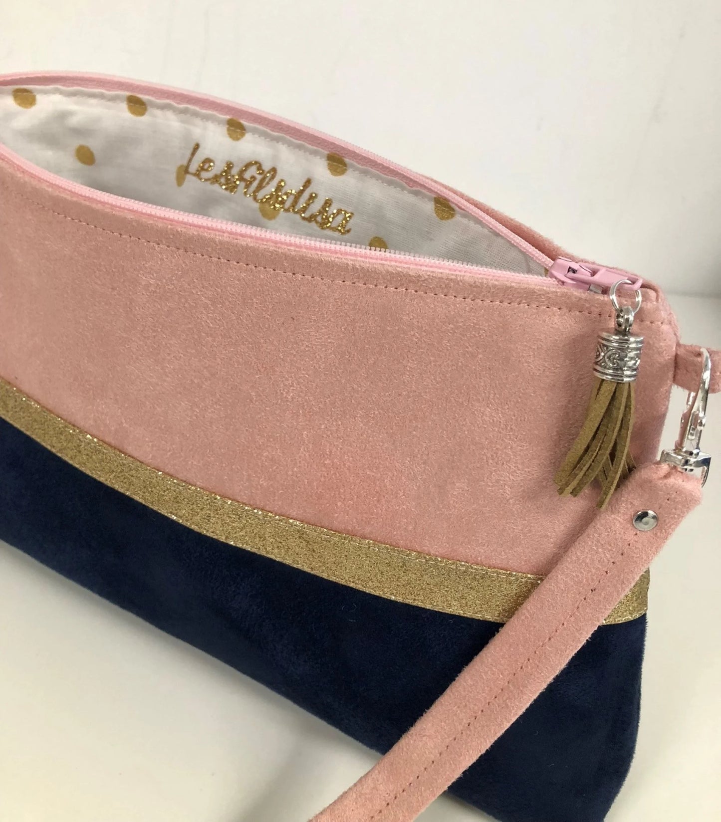 Le sac bandoulière Isa rose poudré et bleu marine à paillettes dorées, ouvert.