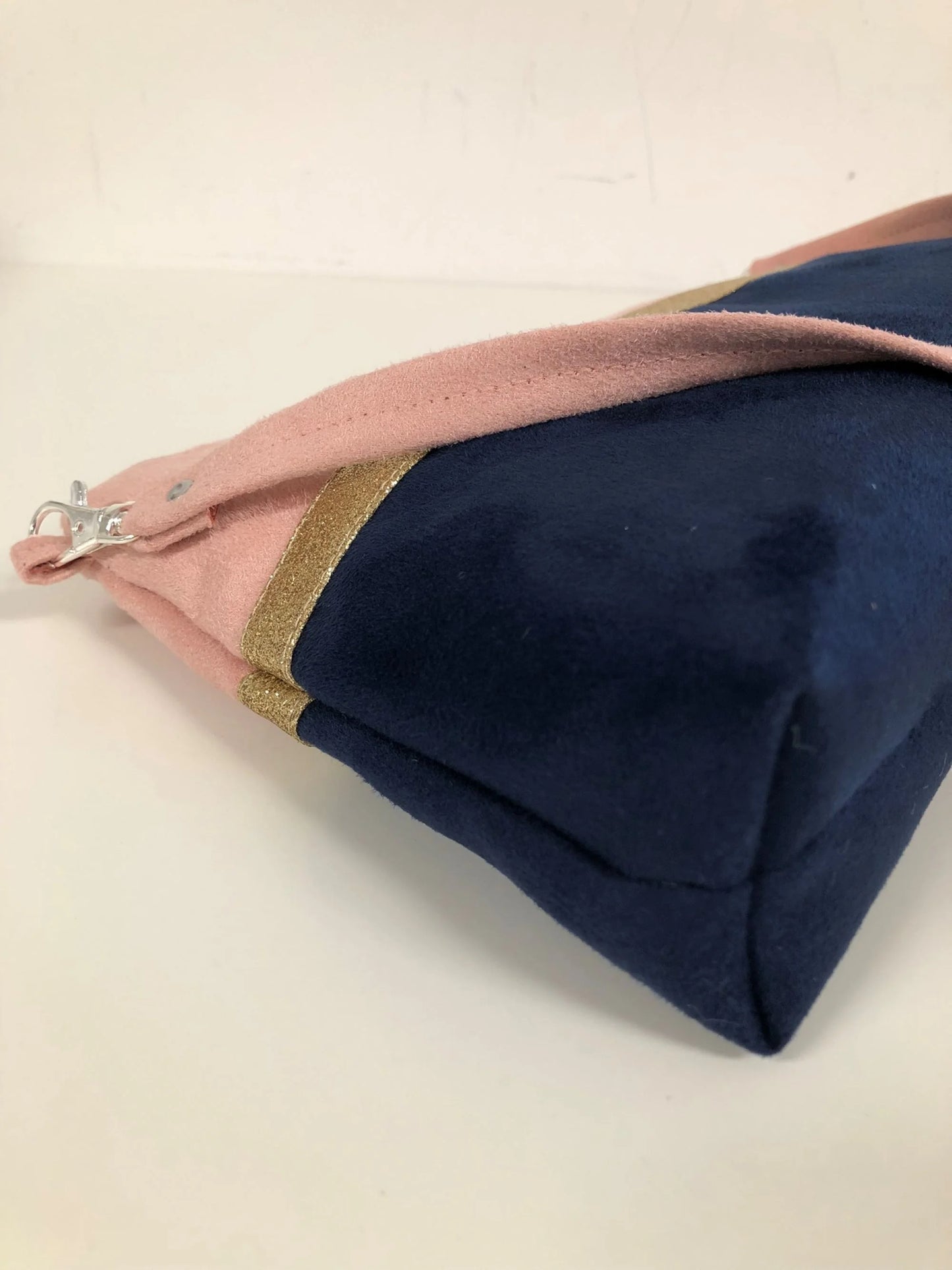 Vue latérale du sac bandoulière Isa rose poudré et bleu marine à paillettes dorées.